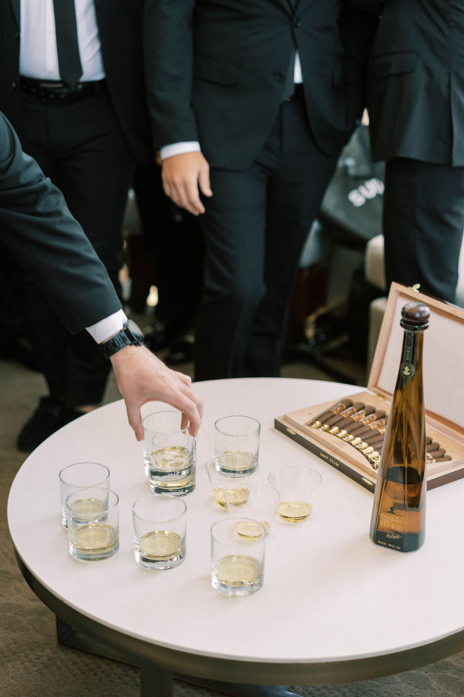 Glasses of champagne being served on a round table at a wedding celebration.