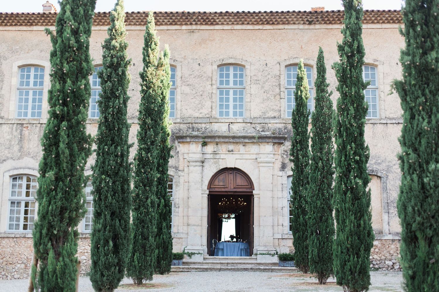 Historic French villa entrance with tall cypress trees creating dramatic symmetrical approach at chateau de moissac.