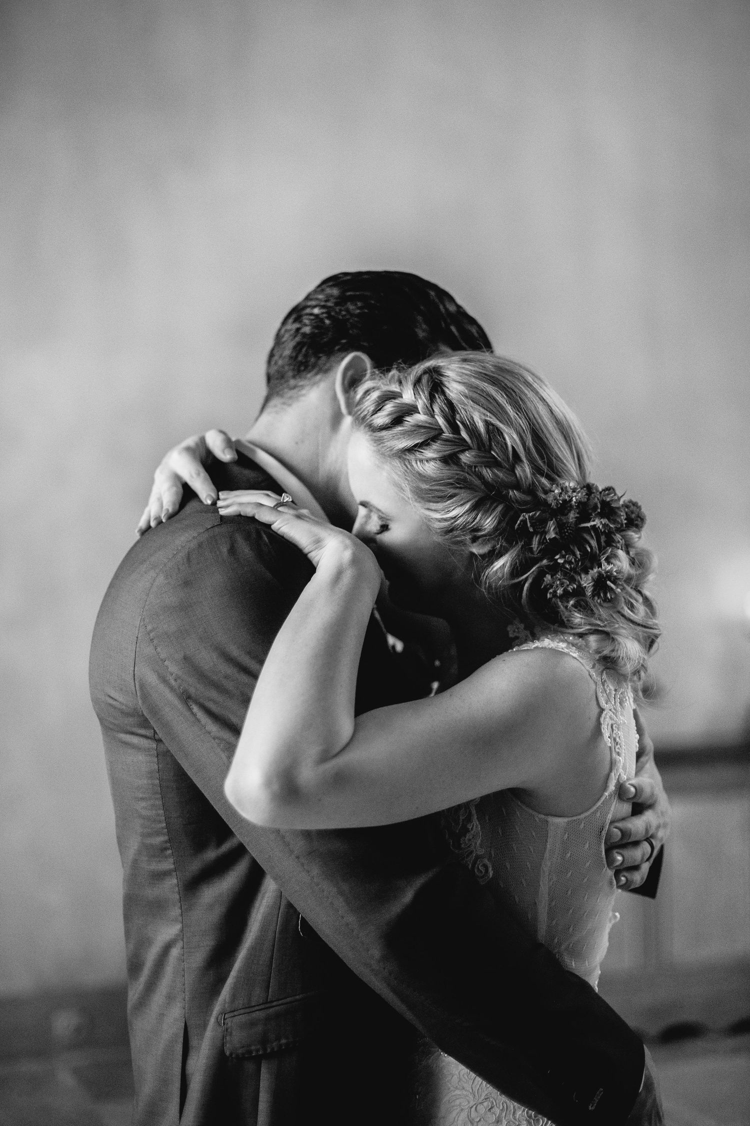 Black and white close-up of an intimate wedding dance embrace.