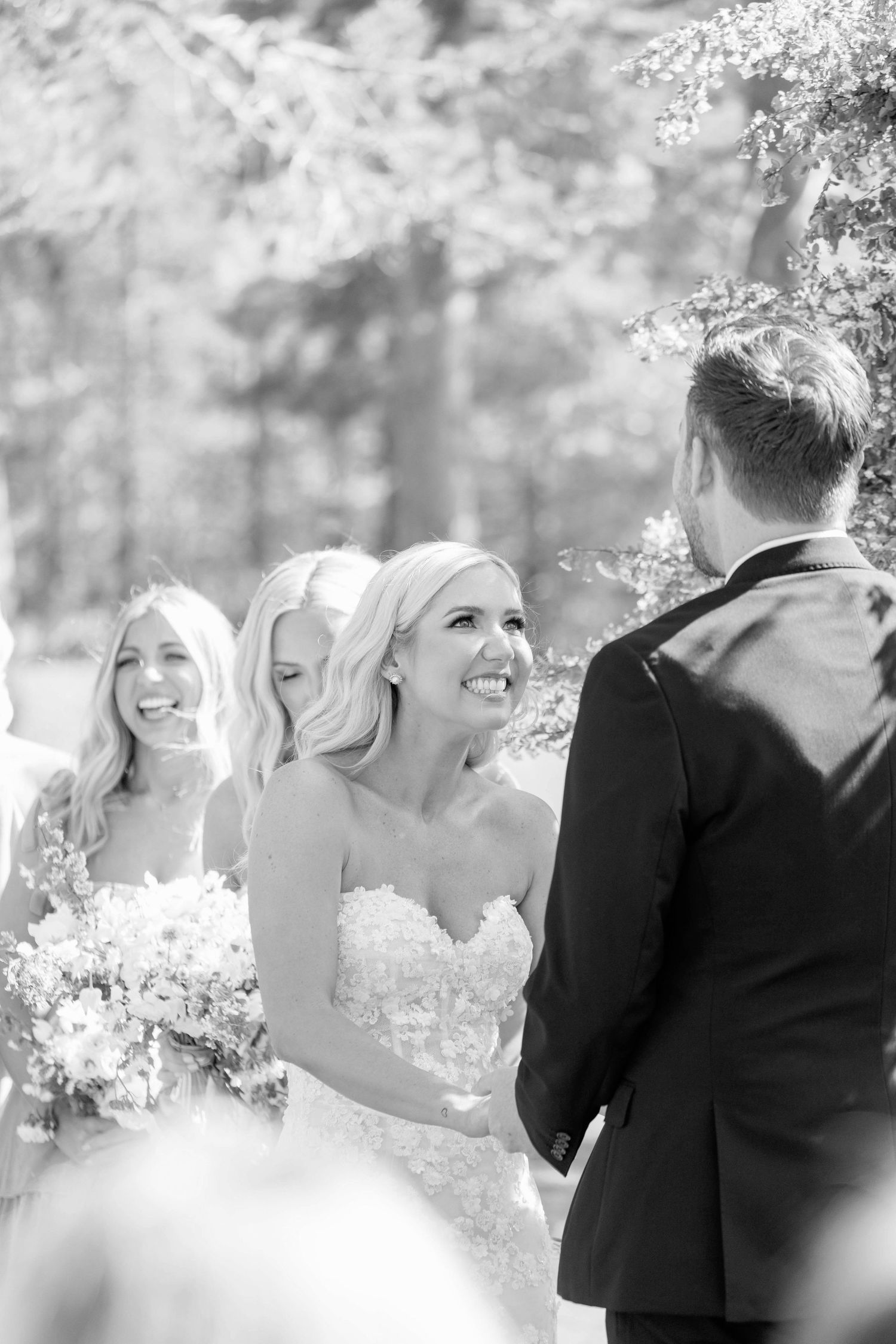 Joyful moments during outdoor wedding ceremony with flowering trees.