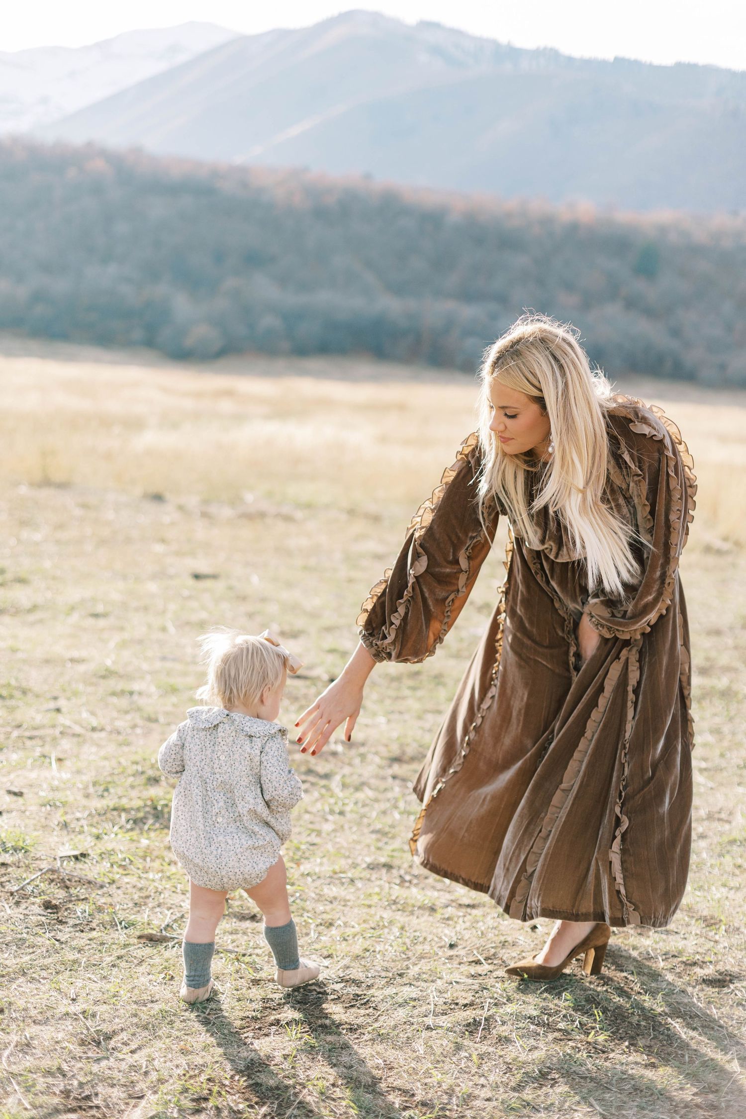 A touching moment between parent and child in a mountain meadow with fall colors.