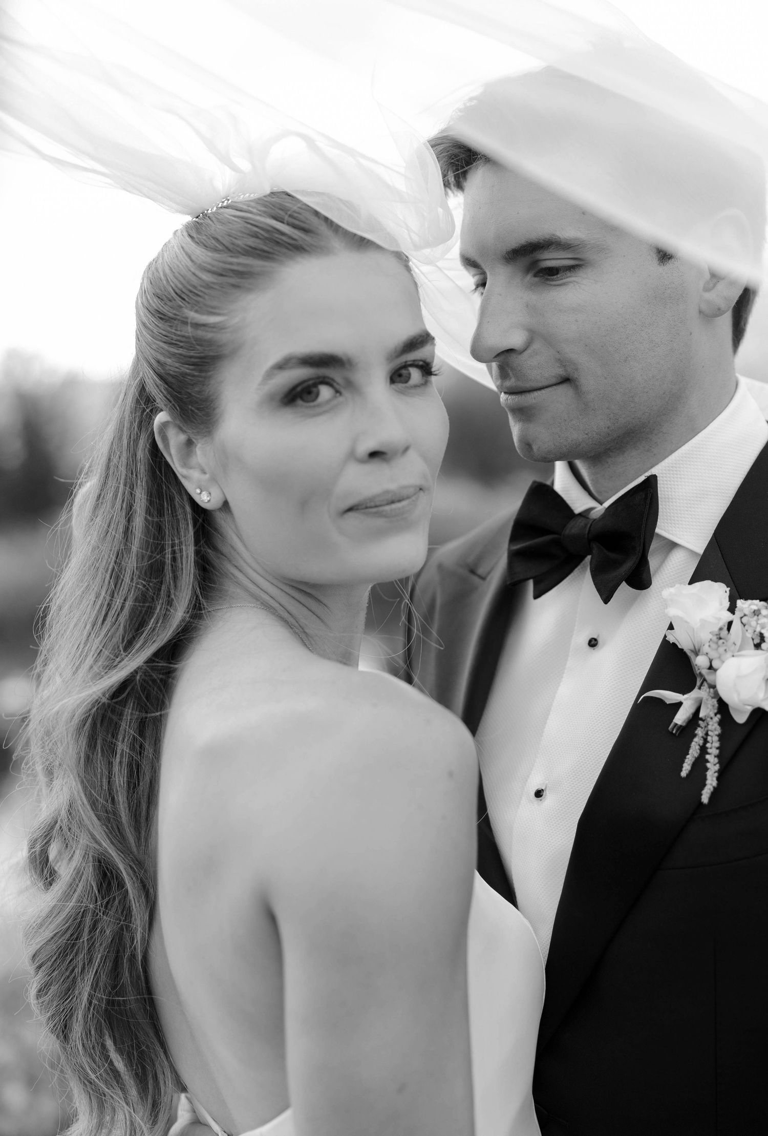 Black and white romantic wedding portraits showing tender moments between a couple in formal attire.