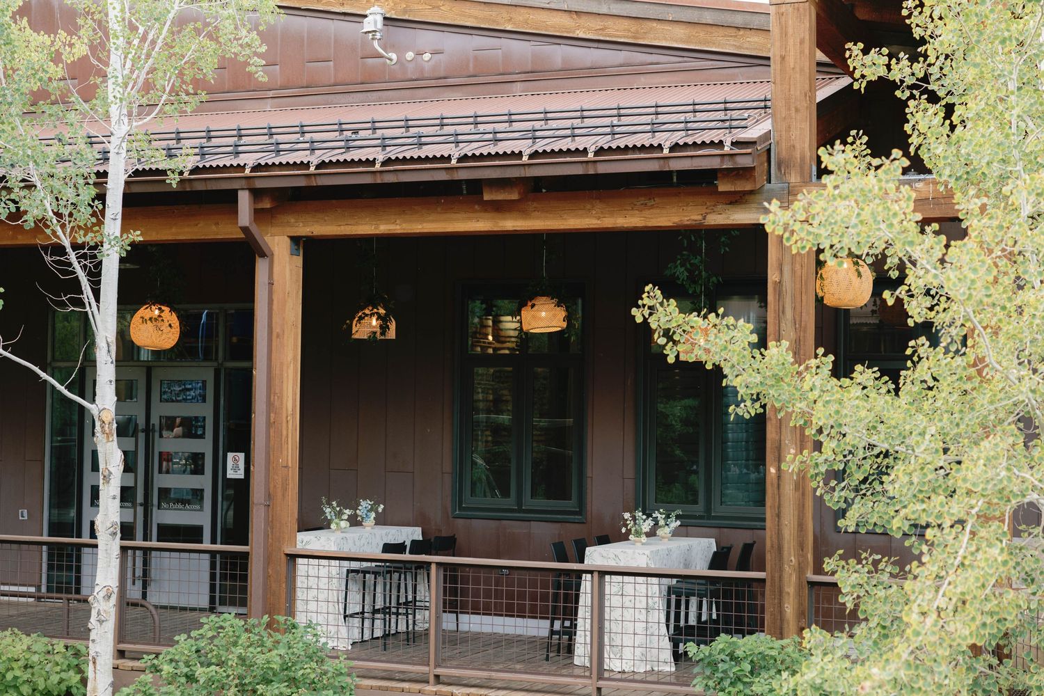 Rustic wooden beams and patio cover with hanging lights at an outdoor wedding venue.