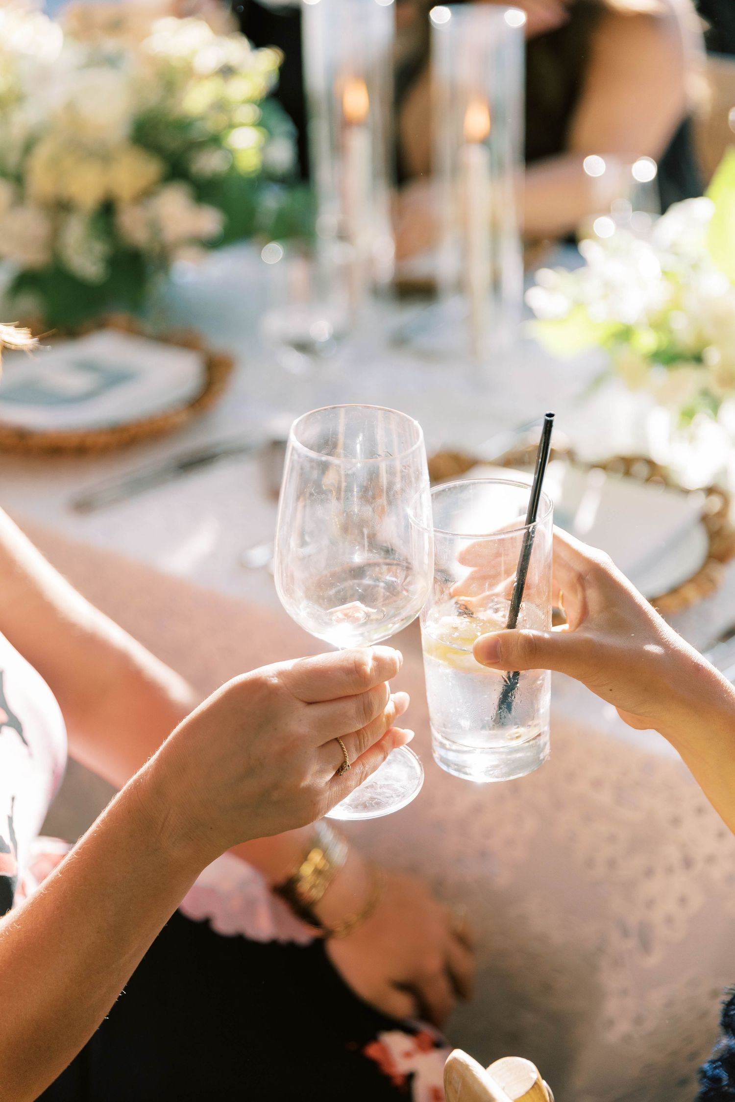 Elegant table settings with wine glasses and drinks at a wedding reception.