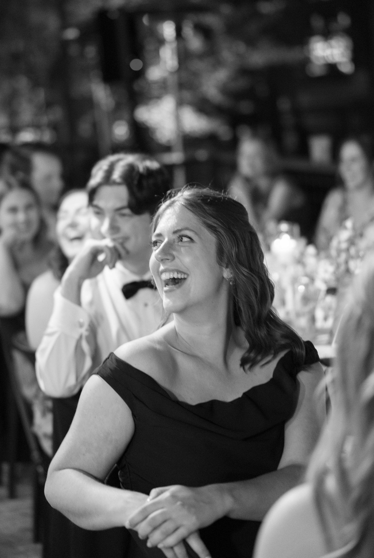 Black and white photo of people dancing and celebrating at a wedding reception.