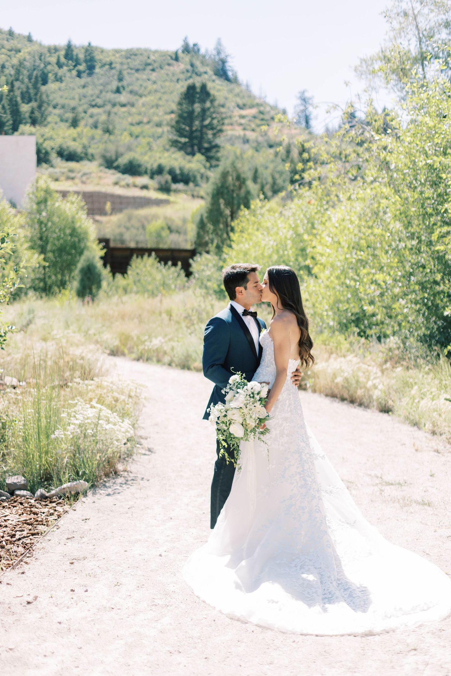 Mountain wedding portrait with couple on scenic dirt path.