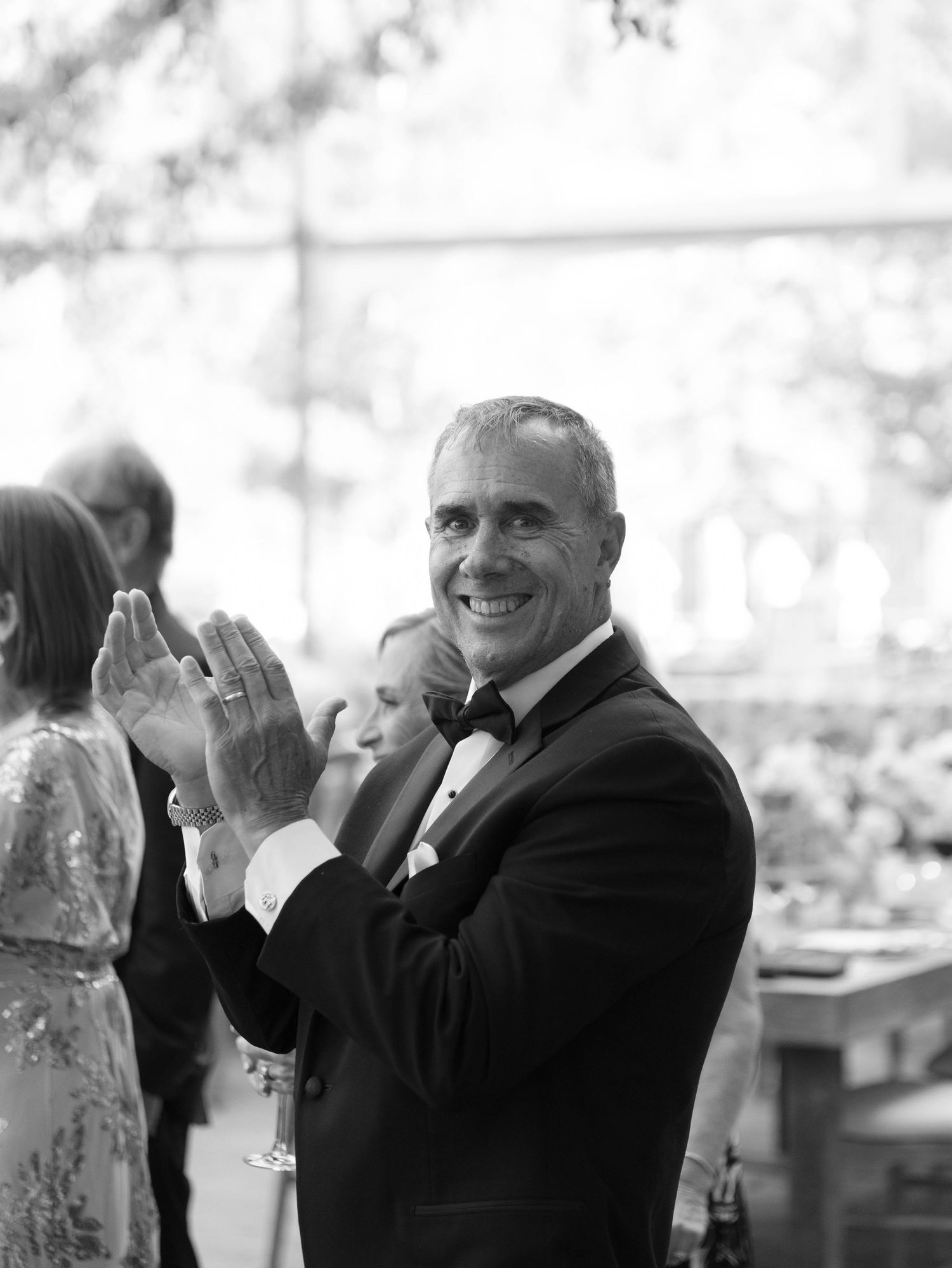 A series of black and white photos showing joyful reactions and applause at a formal event.
