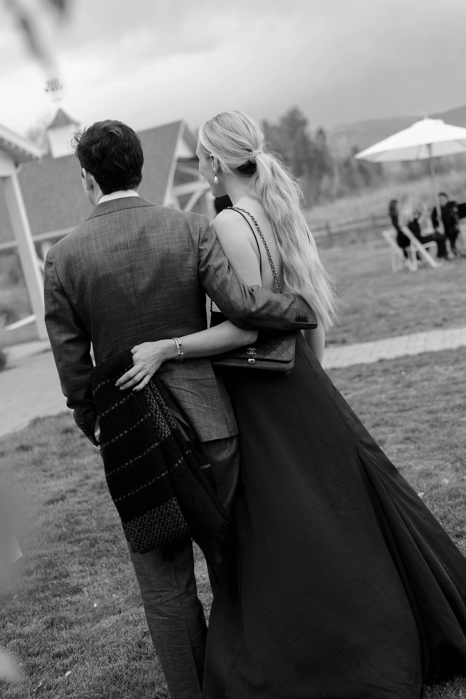 Black and white candid shots of a couple walking together at an outdoor venue.