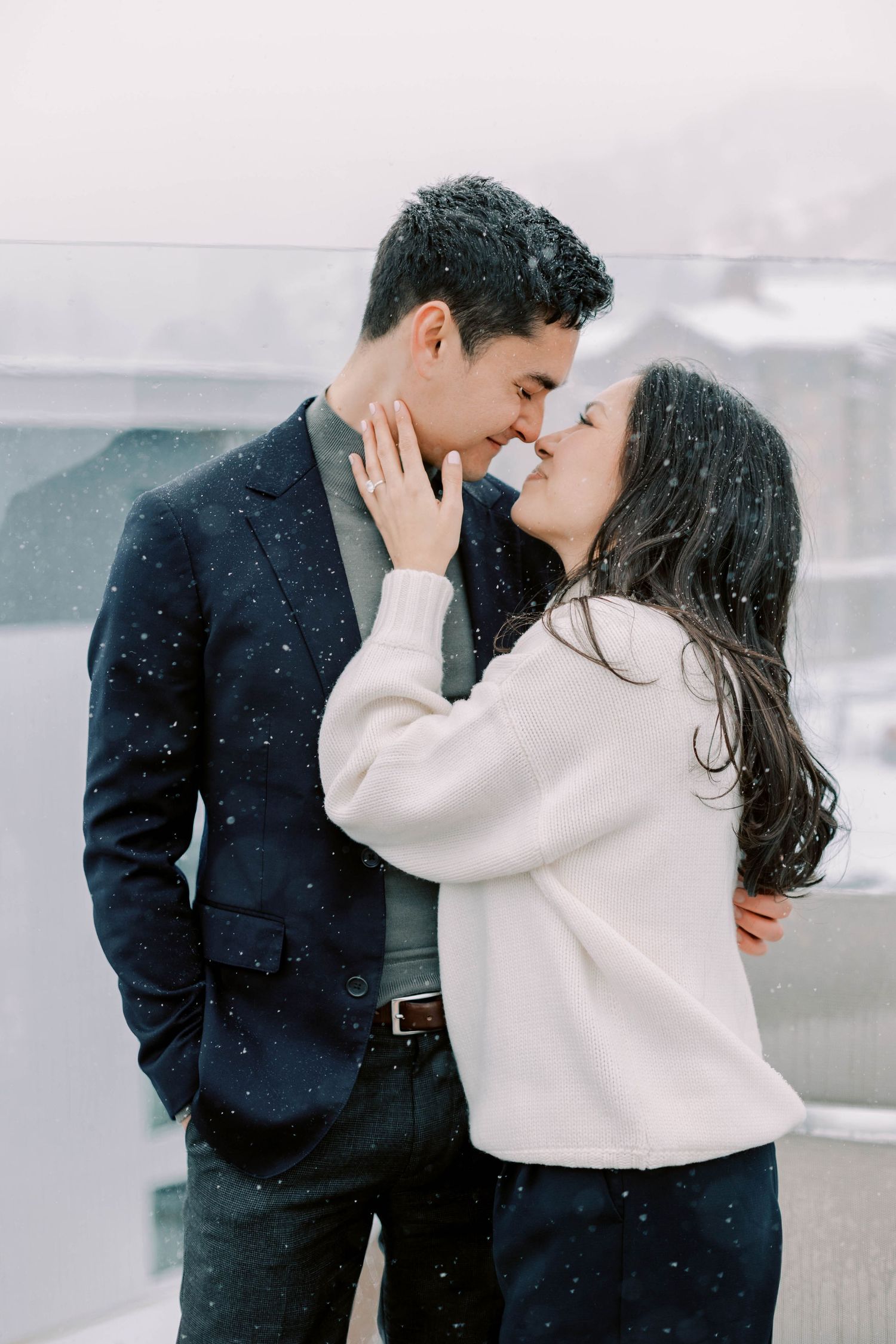 A romantic winter moment between a couple in matching navy and white outfits.