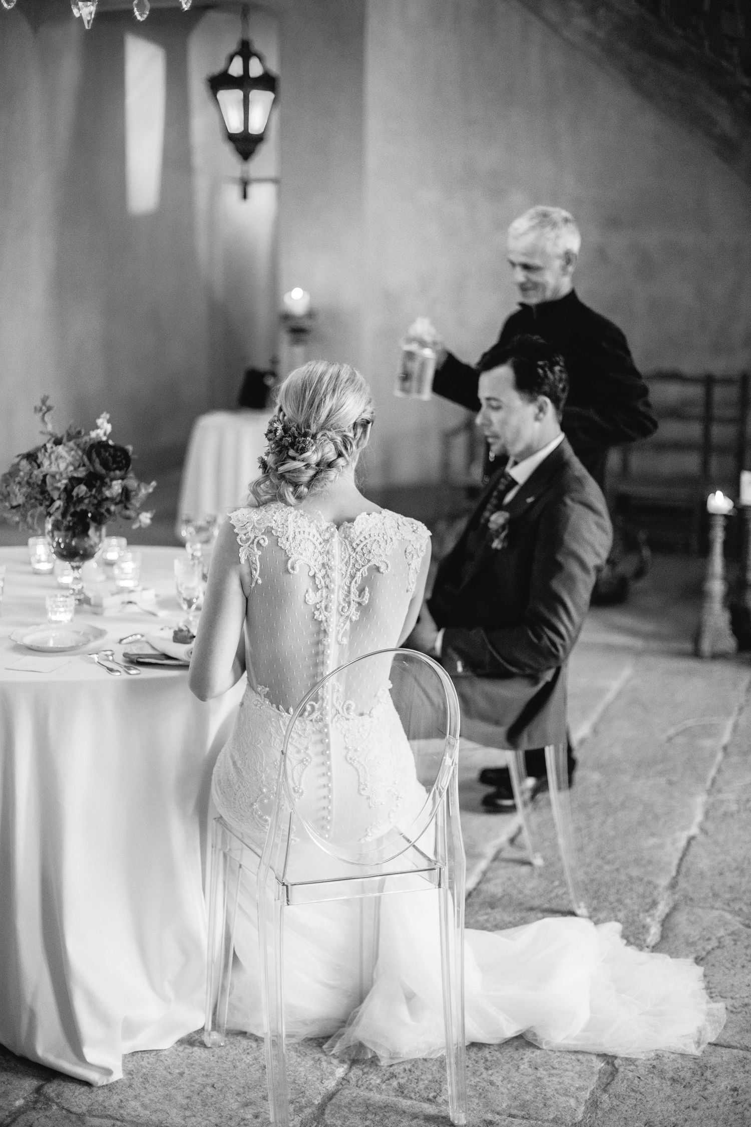 Elegant wedding reception scene featuring intricate lace back wedding dress detail at an intimate table setting at chateau de moissac.