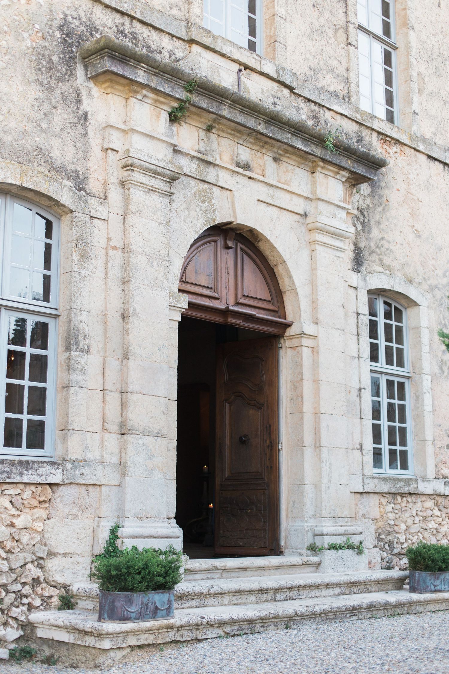 Classical stone doorway with arched entrance and blue-trimmed windows of French chateau chateau de moissac.
