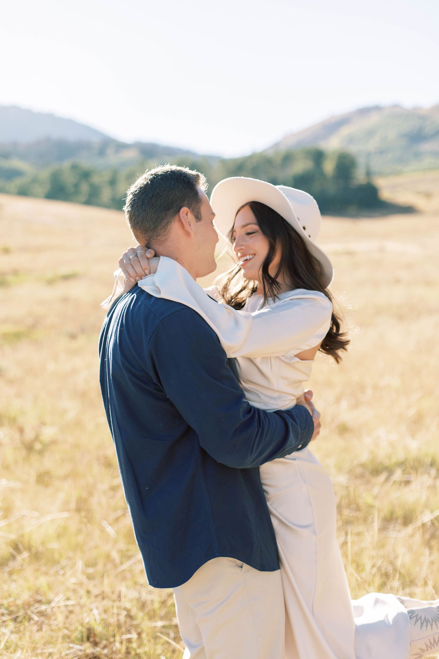 Close up of couple sharing an intimate moment in a mountain field at sunset.
