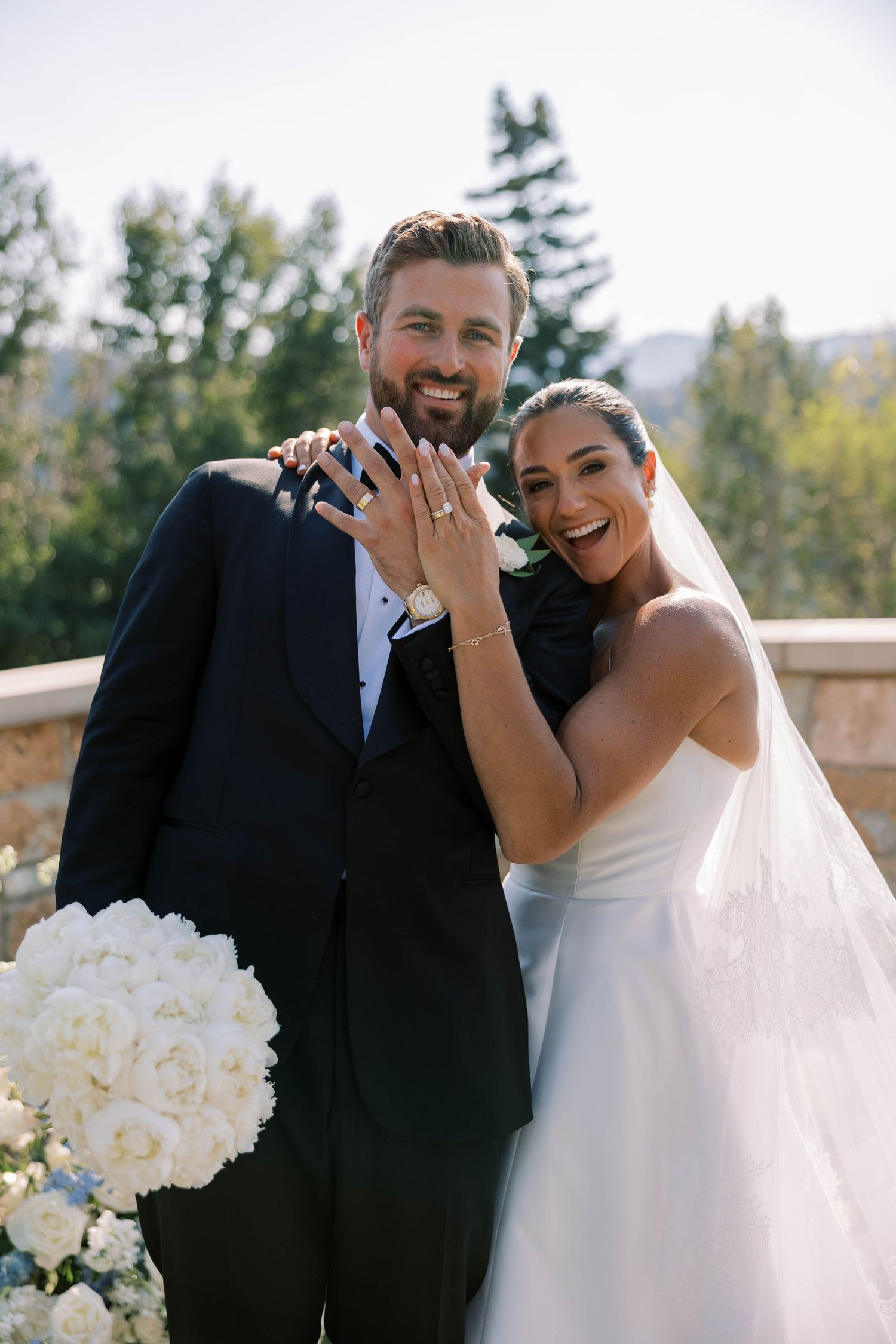 A joyful bride and groom share candid laughs and embraces in an outdoor wedding photo series.