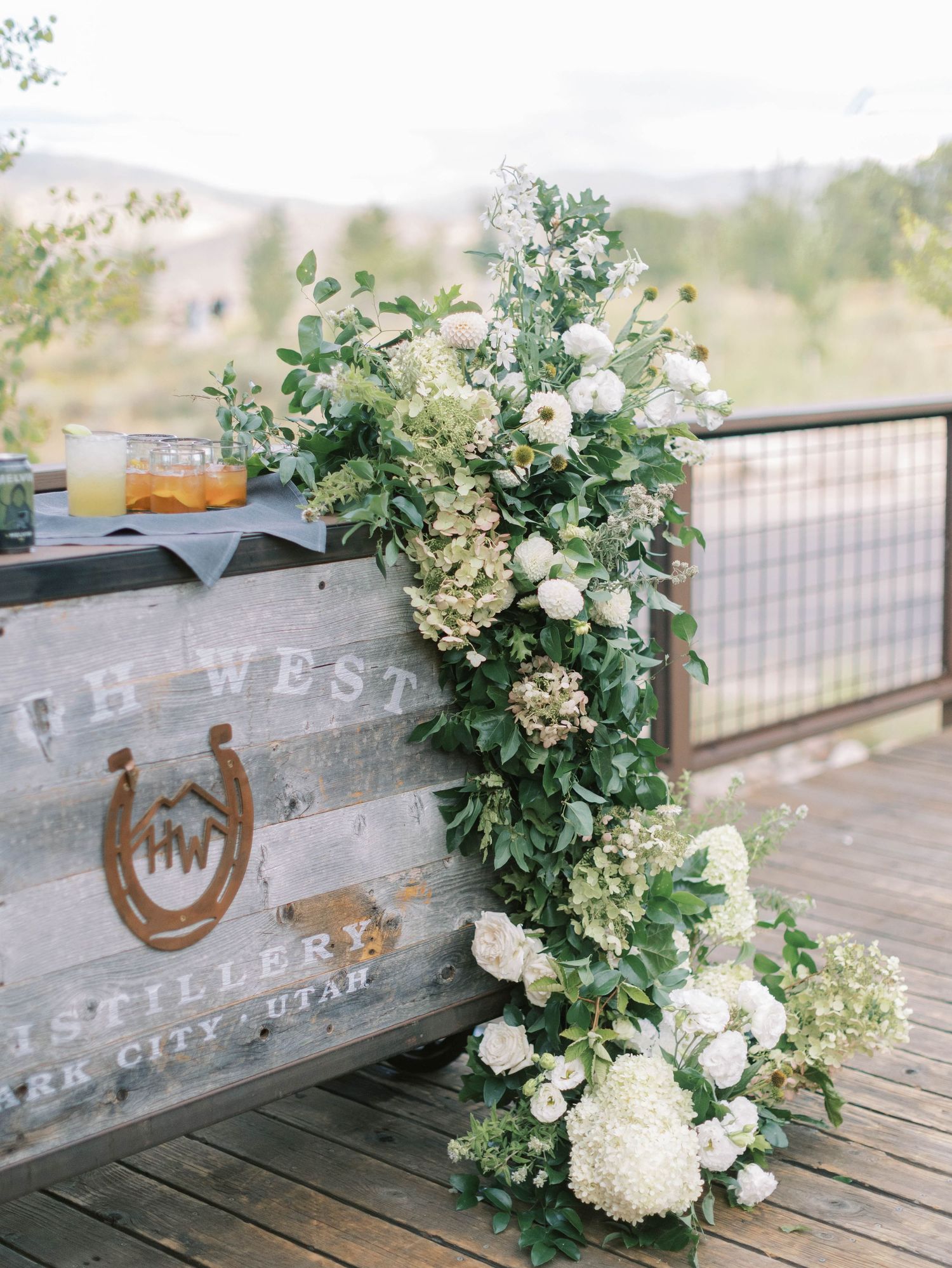 Rustic wooden crate decorated with white floral arrangements and a horseshoe emblem reading 'The West'.
