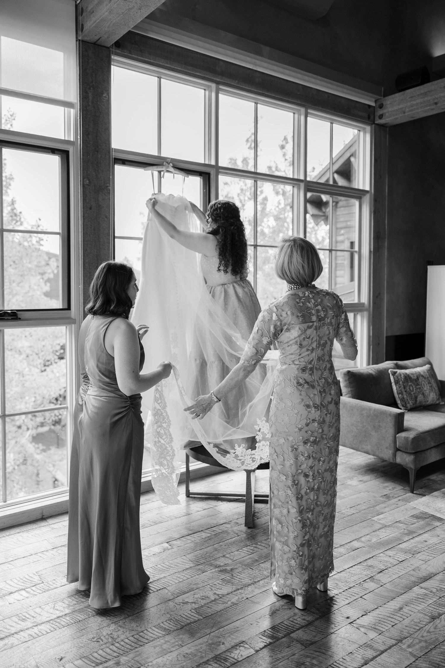 Black and white photos showing wedding preparations in a rustic room with wooden floors and large windows.