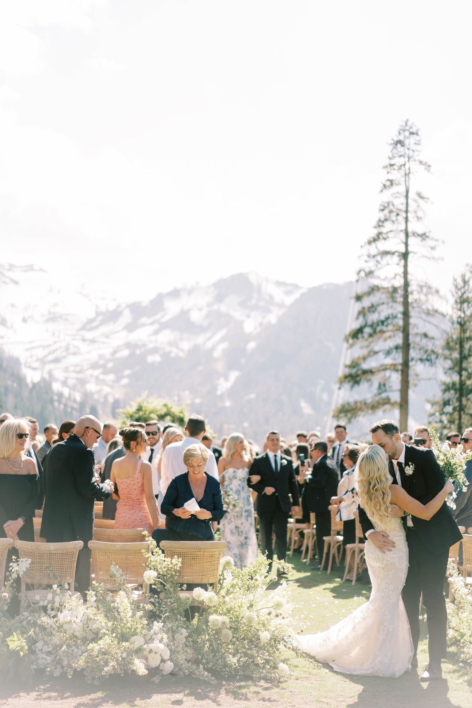 Outdoor mountain wedding ceremony with guests seated on wooden chairs at everline resort in lake tahoe.