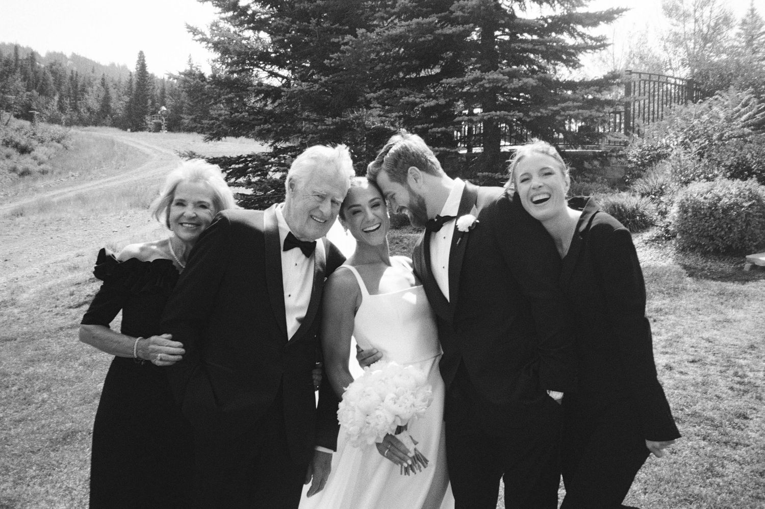 A sequence of black and white wedding photos showing candid moments between a couple and guests outdoors.