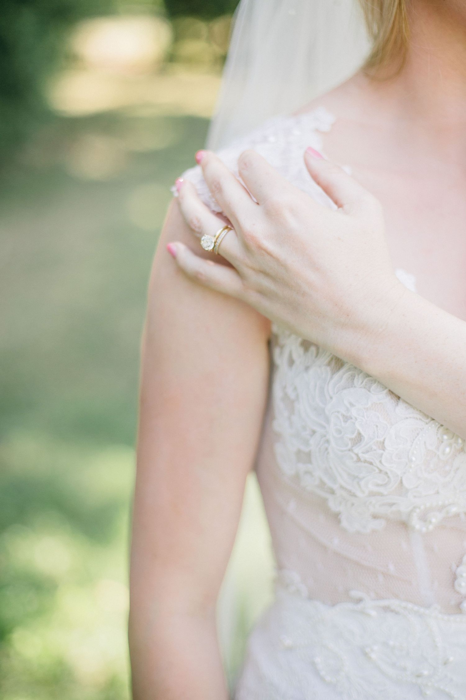 Elegant diamond engagement ring shown with lace wedding dress detail of berta bridal gown.
