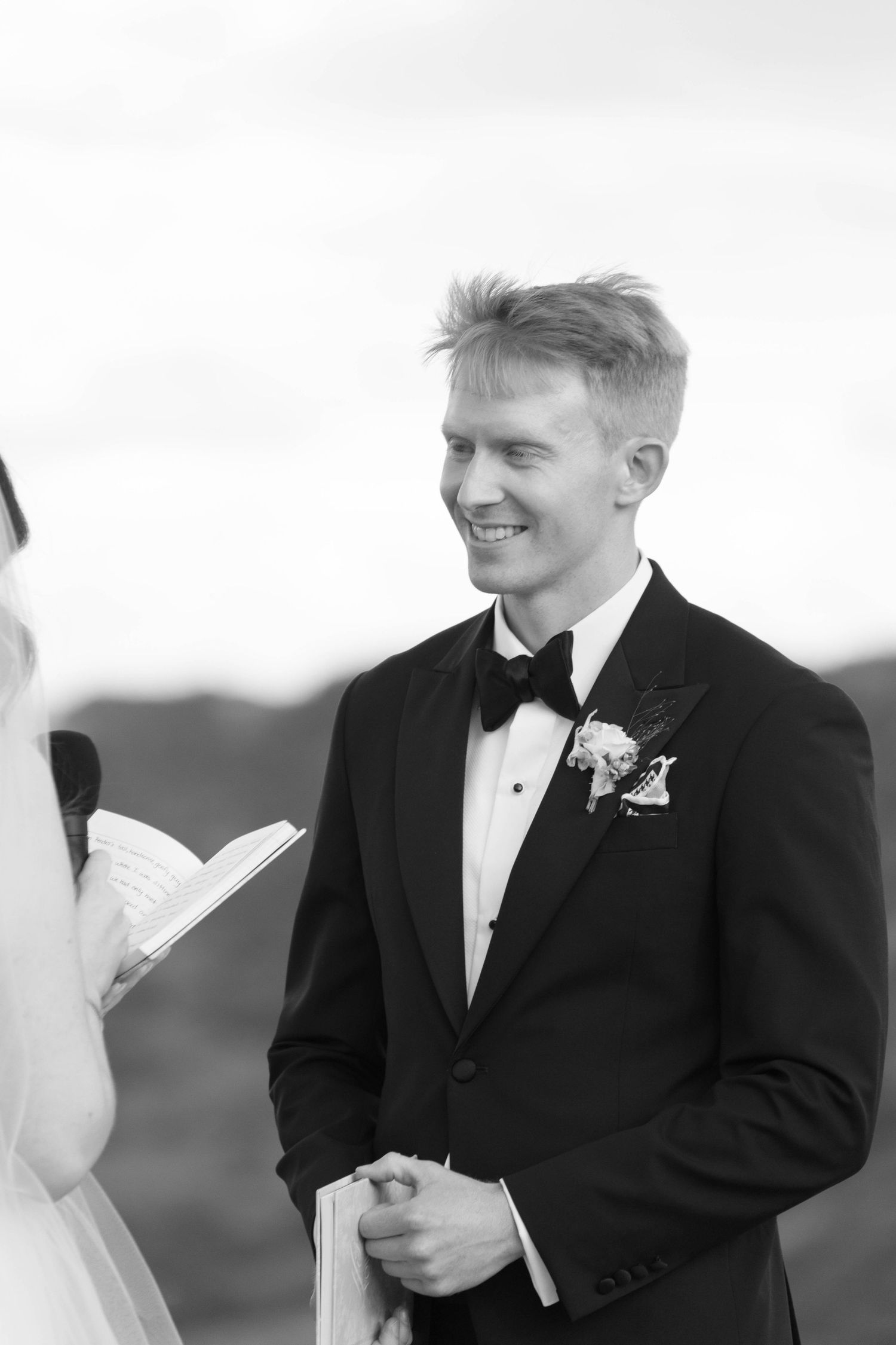 Black and white wedding portrait showing joyful expressions during an intimate moment.