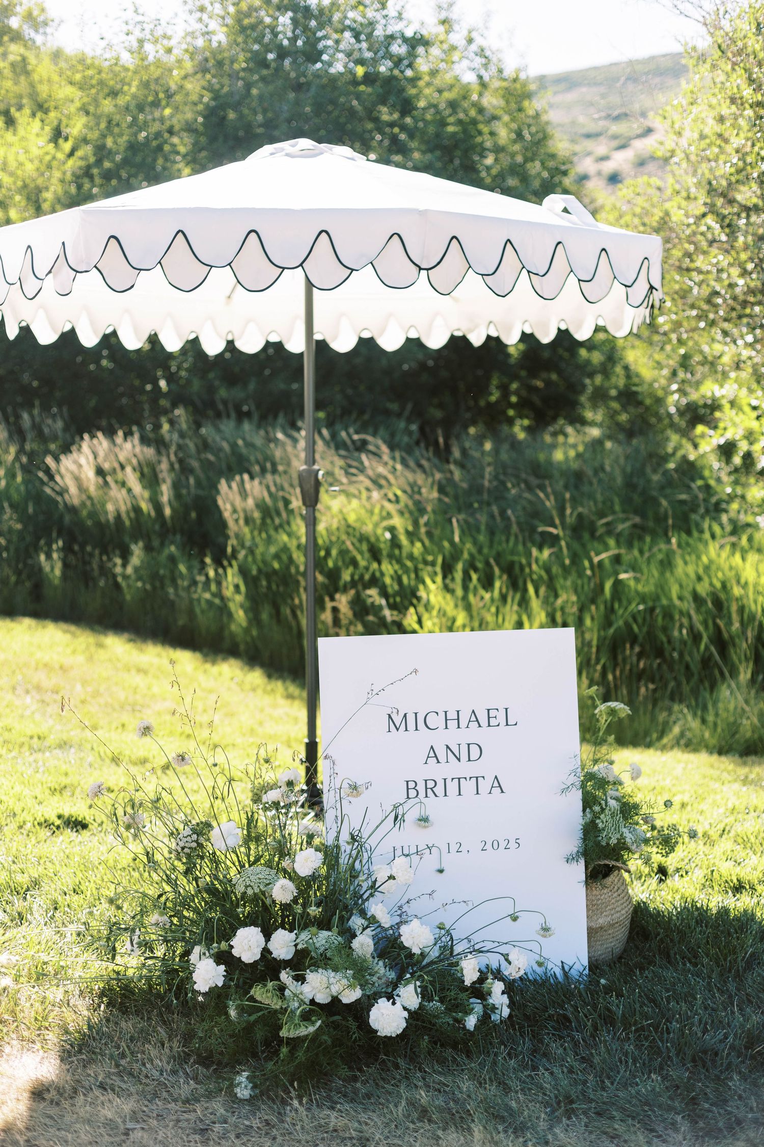 White decorative umbrellas with scalloped edges line up in a sunny garden setting creating an elegant outdoor display.