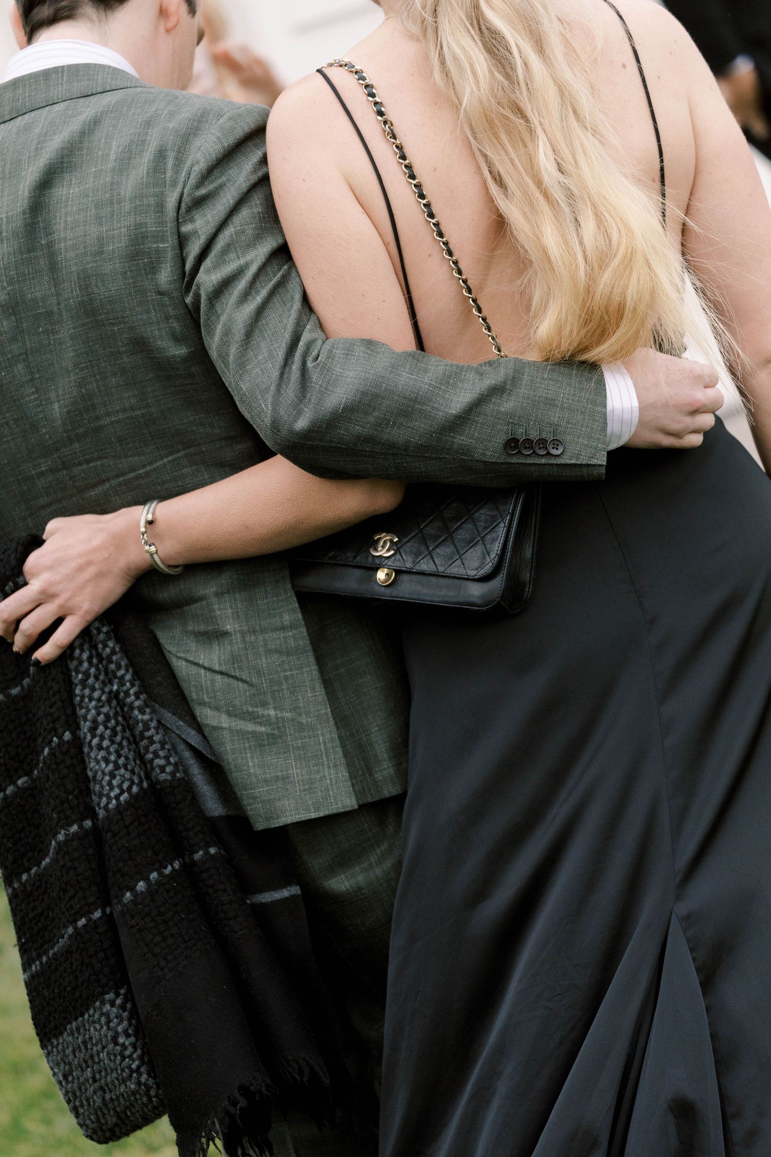 Close-up detail shots of a couple embracing at an outdoor event.