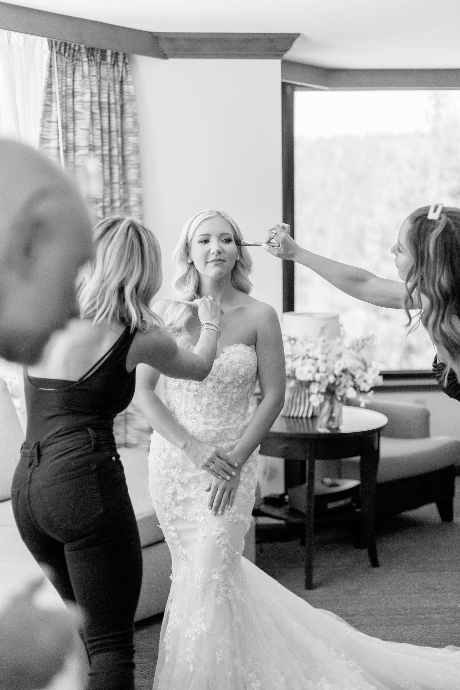 Wedding preparation scene showing final touches being applied to the bride's look.