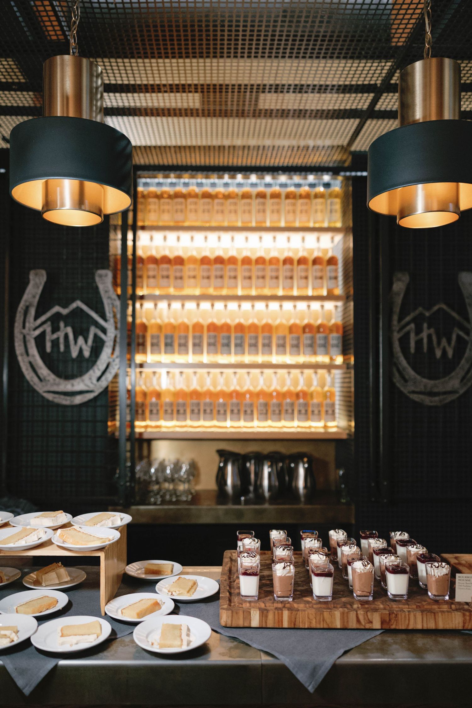 Modern restaurant interior with industrial lighting and place settings arranged on a long bar.