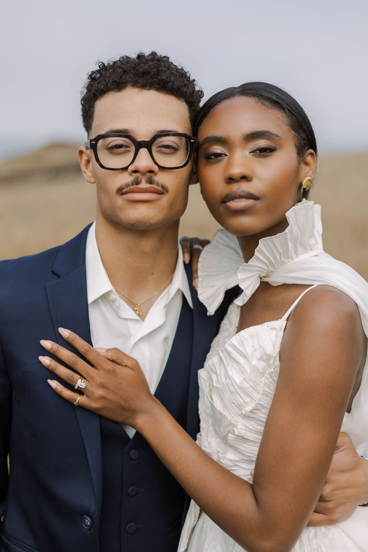 A couple in wedding attire share intimate poses together in a series of romantic outdoor portraits.