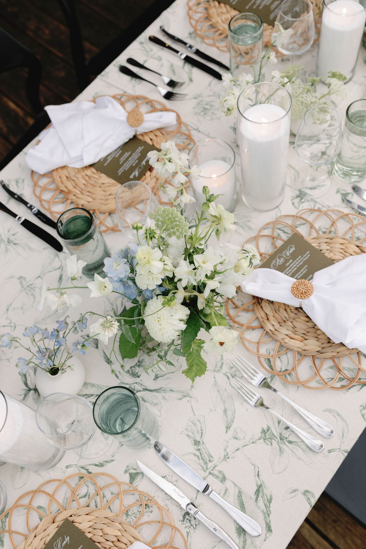 Elegant table settings with woven placemats, white linens, and delicate floral arrangements create a romantic dining atmosphere.