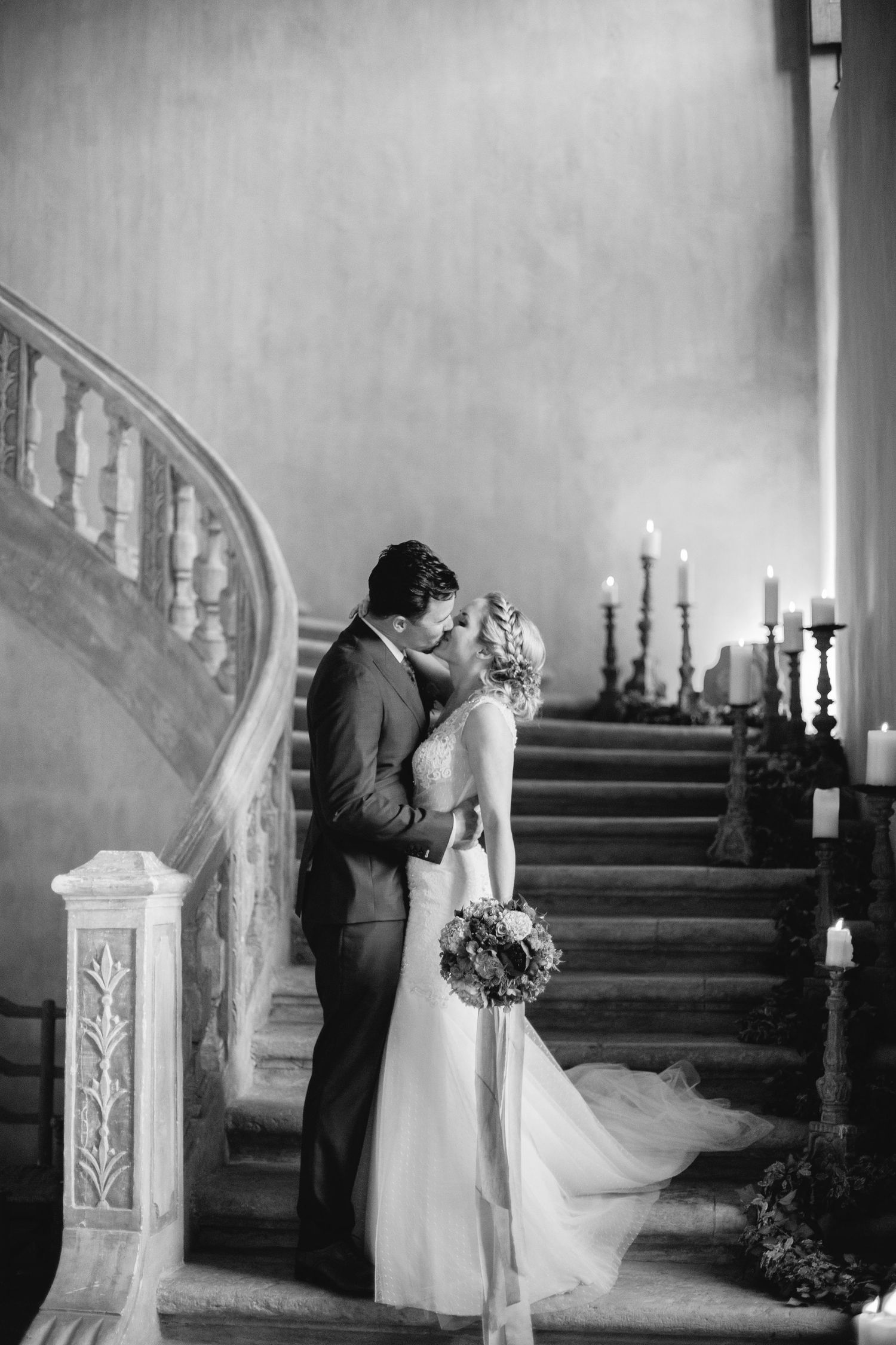 Romantic wedding moment on a candlelit staircase in black and white at chateau de moissac.