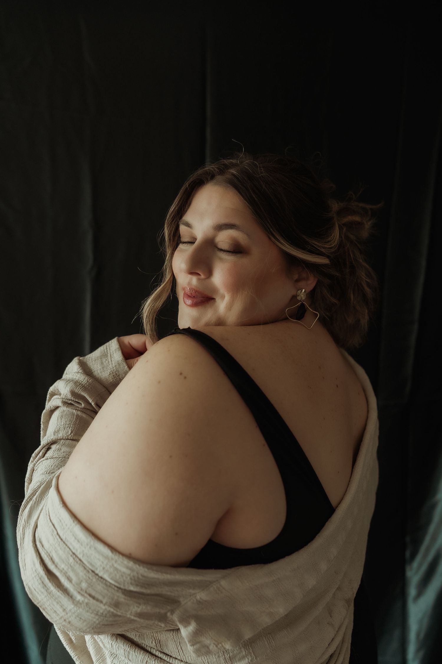 Inclusive boudoir photography session in Grand Rapids featuring a confident woman in a body-positive studio environment