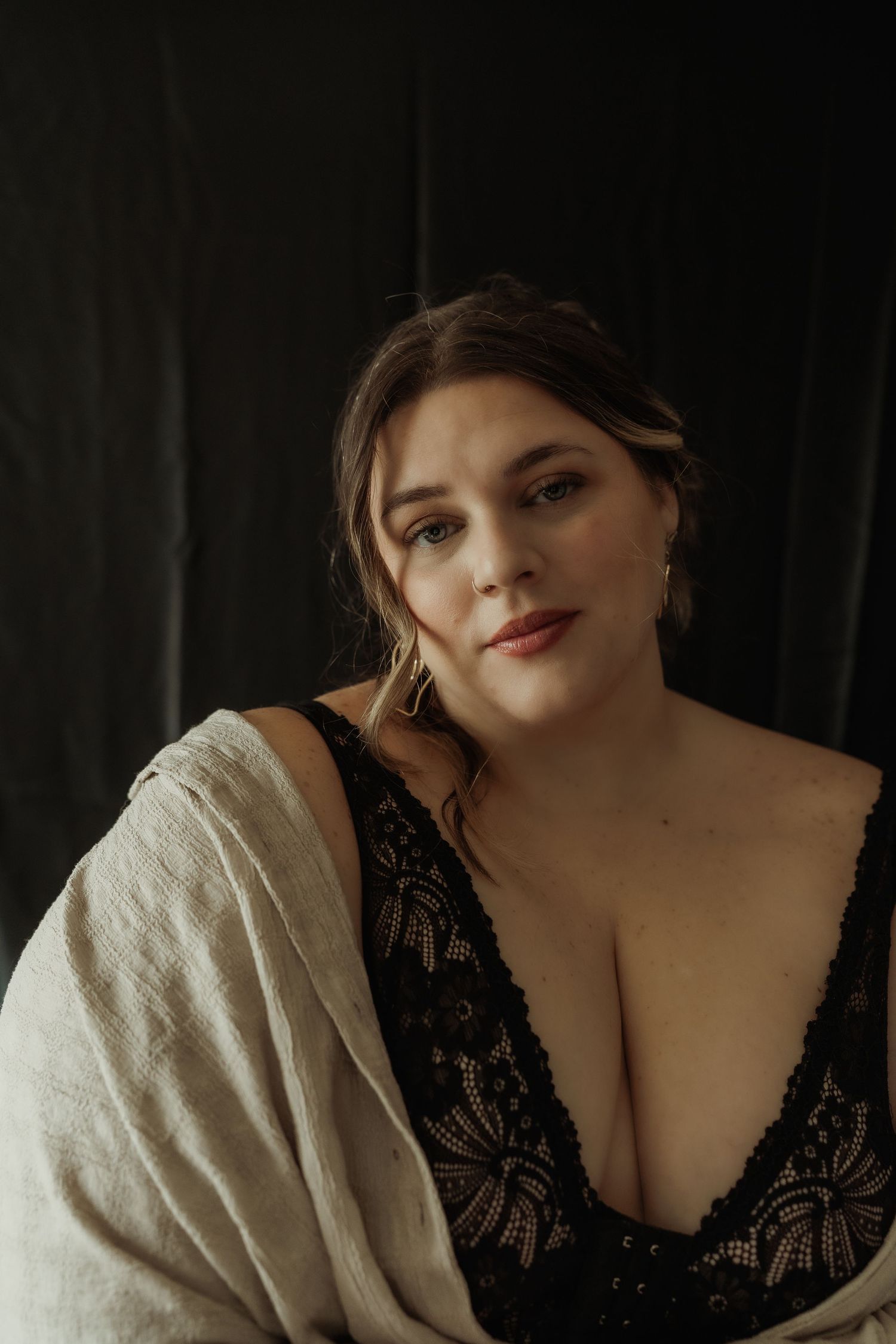 Inclusive boudoir photography session in Grand Rapids featuring a confident woman in a body-positive studio environment