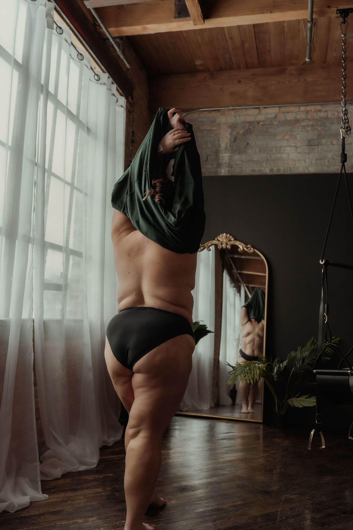 Inclusive boudoir photography session in Grand Rapids featuring a confident woman in a body-positive studio environment