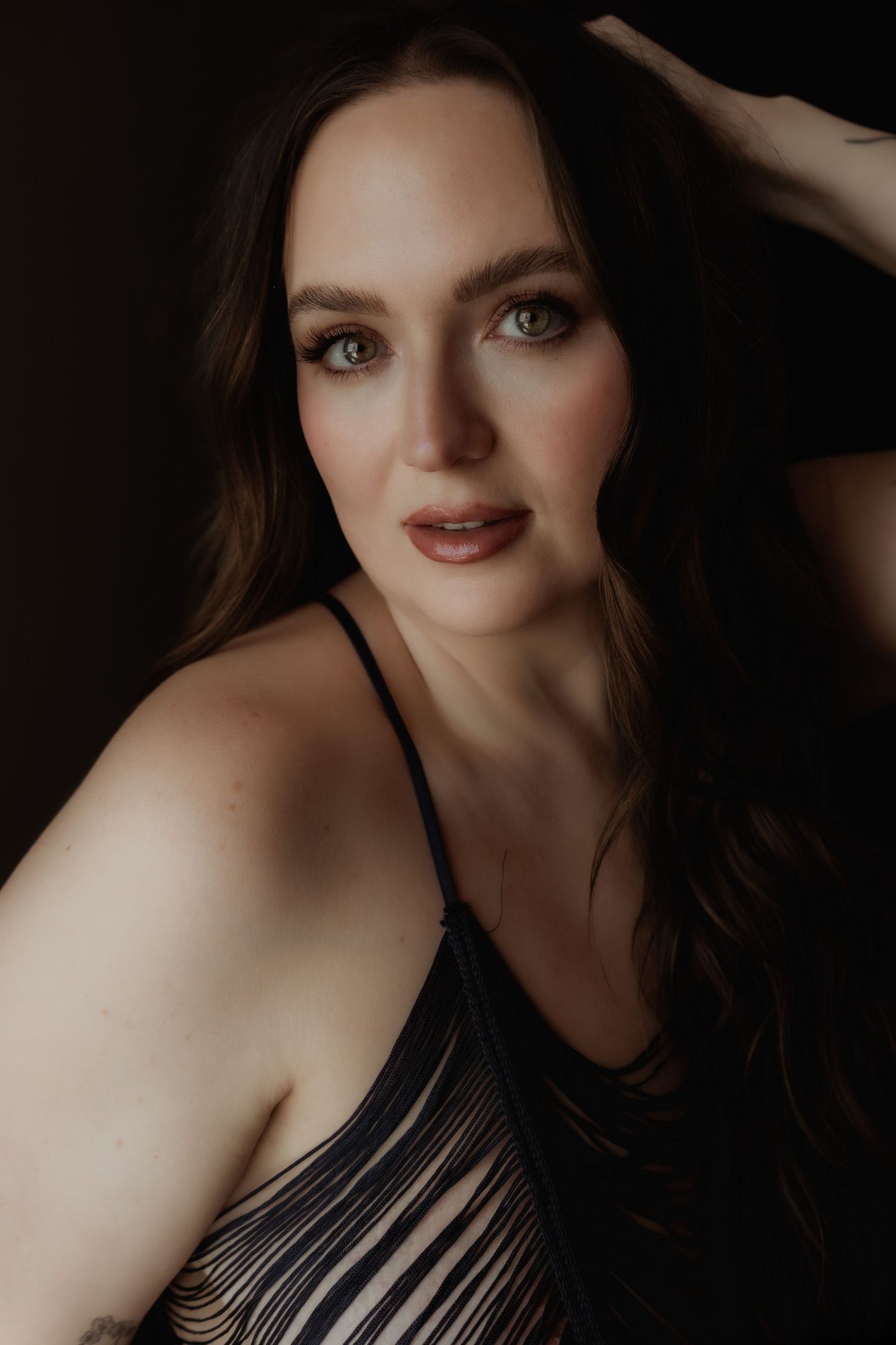 Inclusive boudoir photography session in Grand Rapids featuring a confident woman in a body-positive studio environment