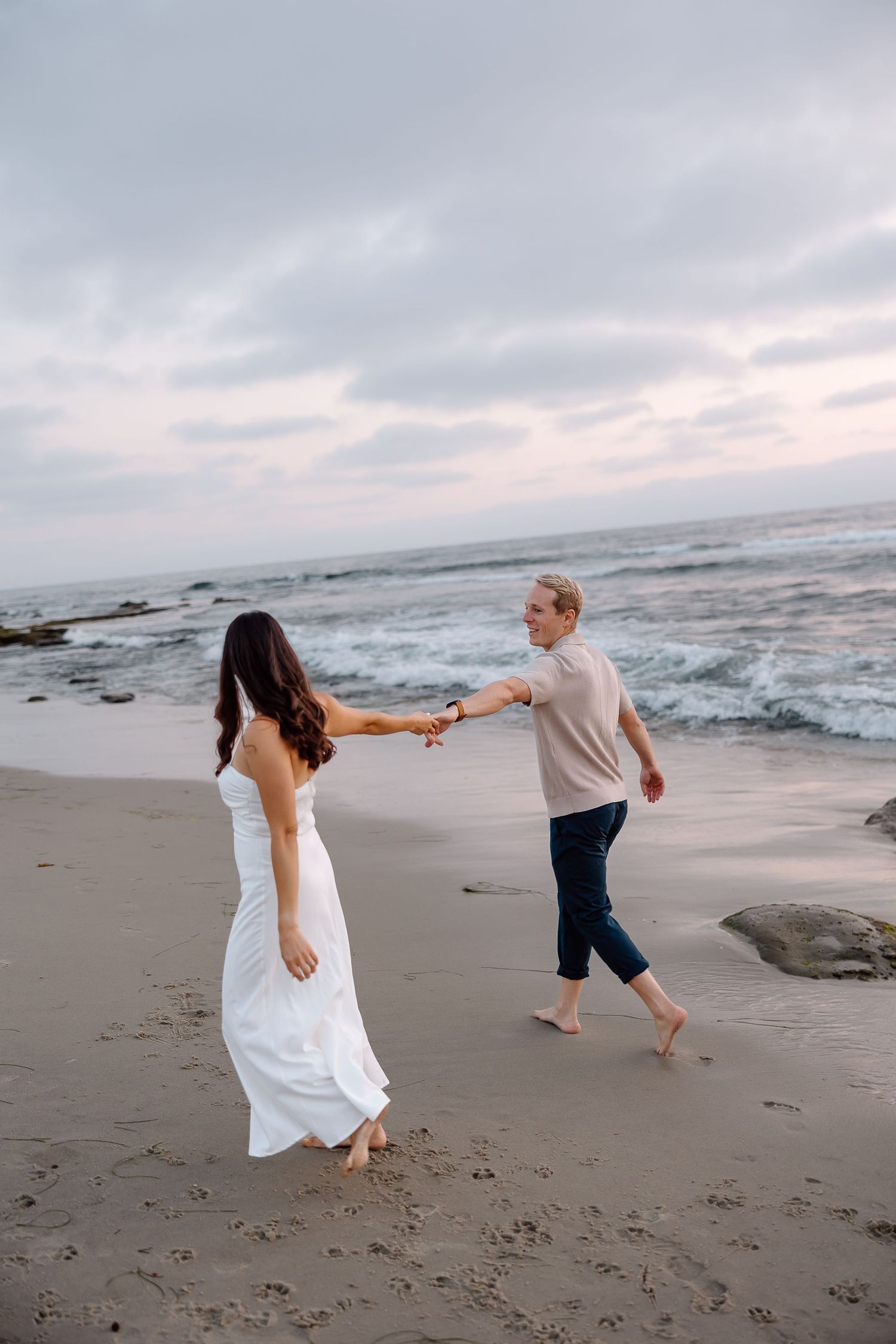 Romantic beach engagement session at Ocean City, Maryland with soft waves in the background