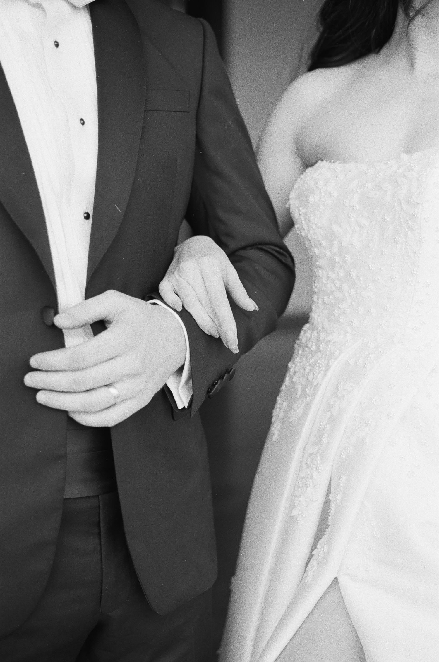 Groom adjusting his tie captured on 35mm film with classic, timeless tones