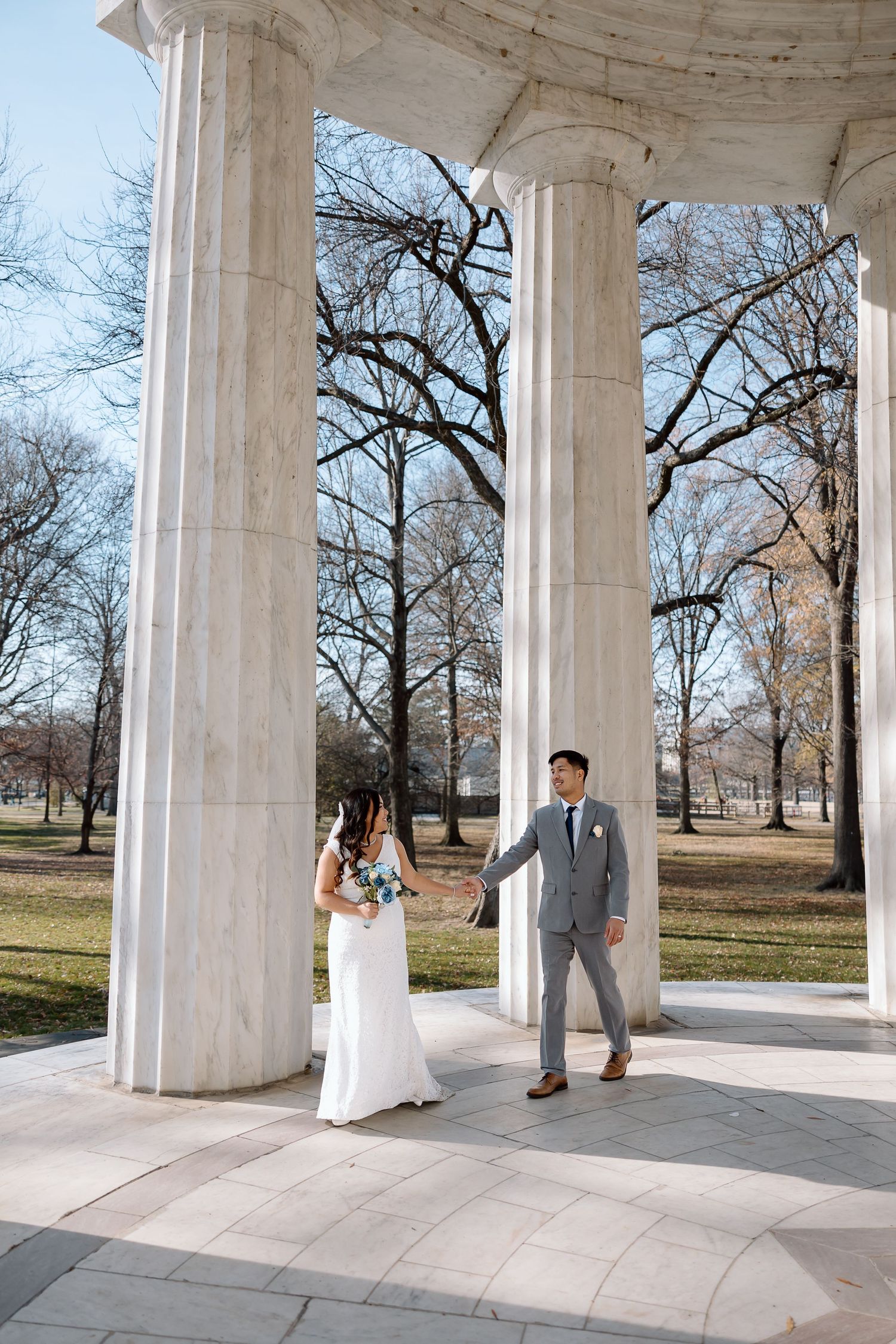 Candid newlywed moment captured at the DC War Memorial during a National Mall elopement.
