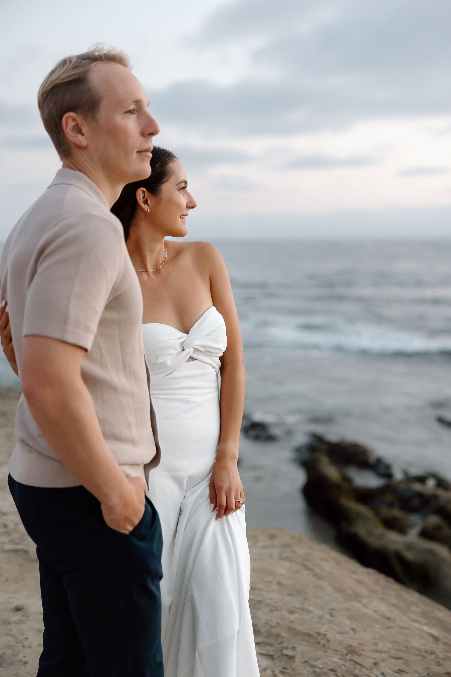 Engagement photos on the sandy waterfront at Sandy Point State Park overlooking the Bay Bridge