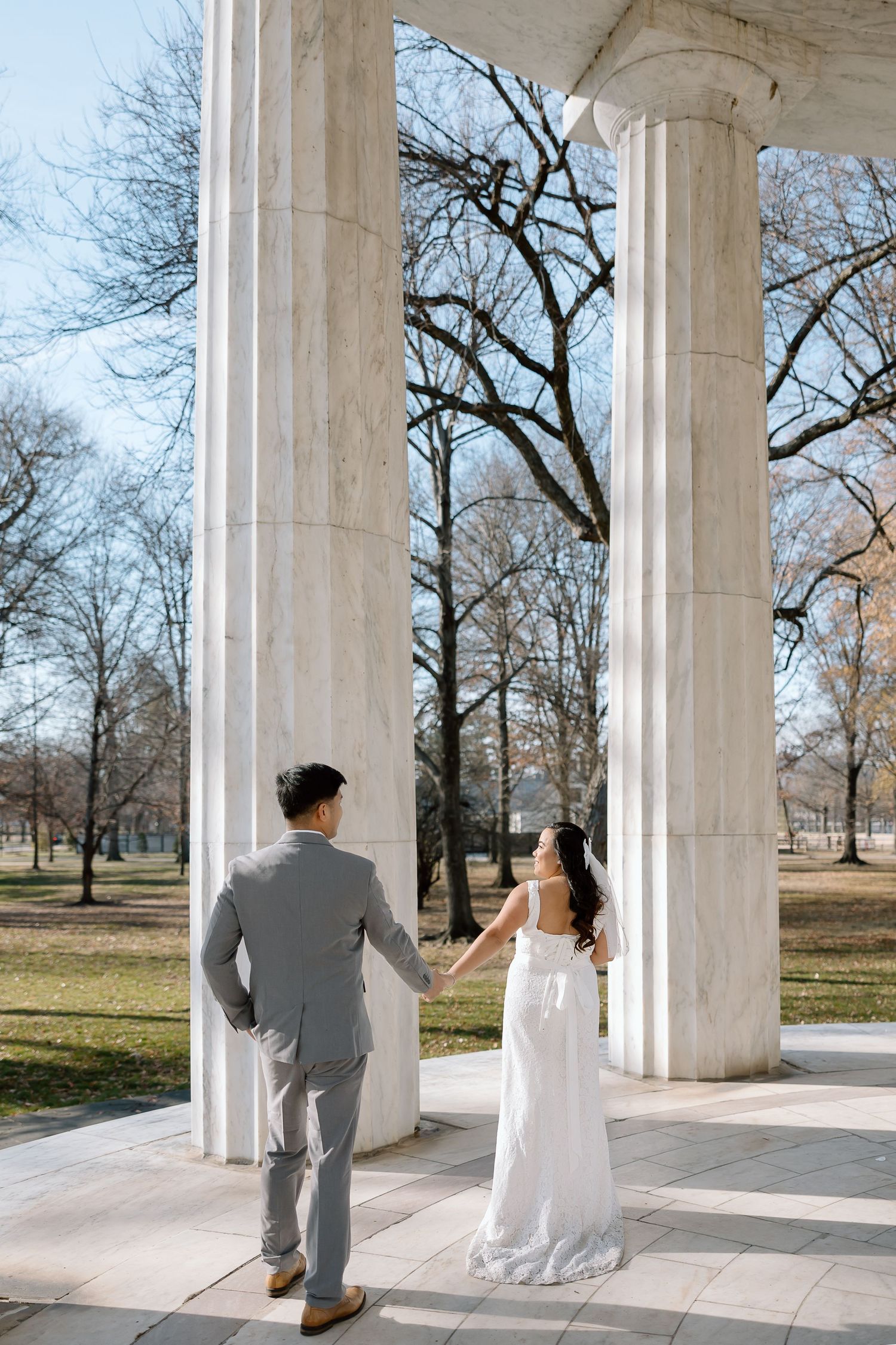 Candid newlywed moment captured at the DC War Memorial during a National Mall elopement.