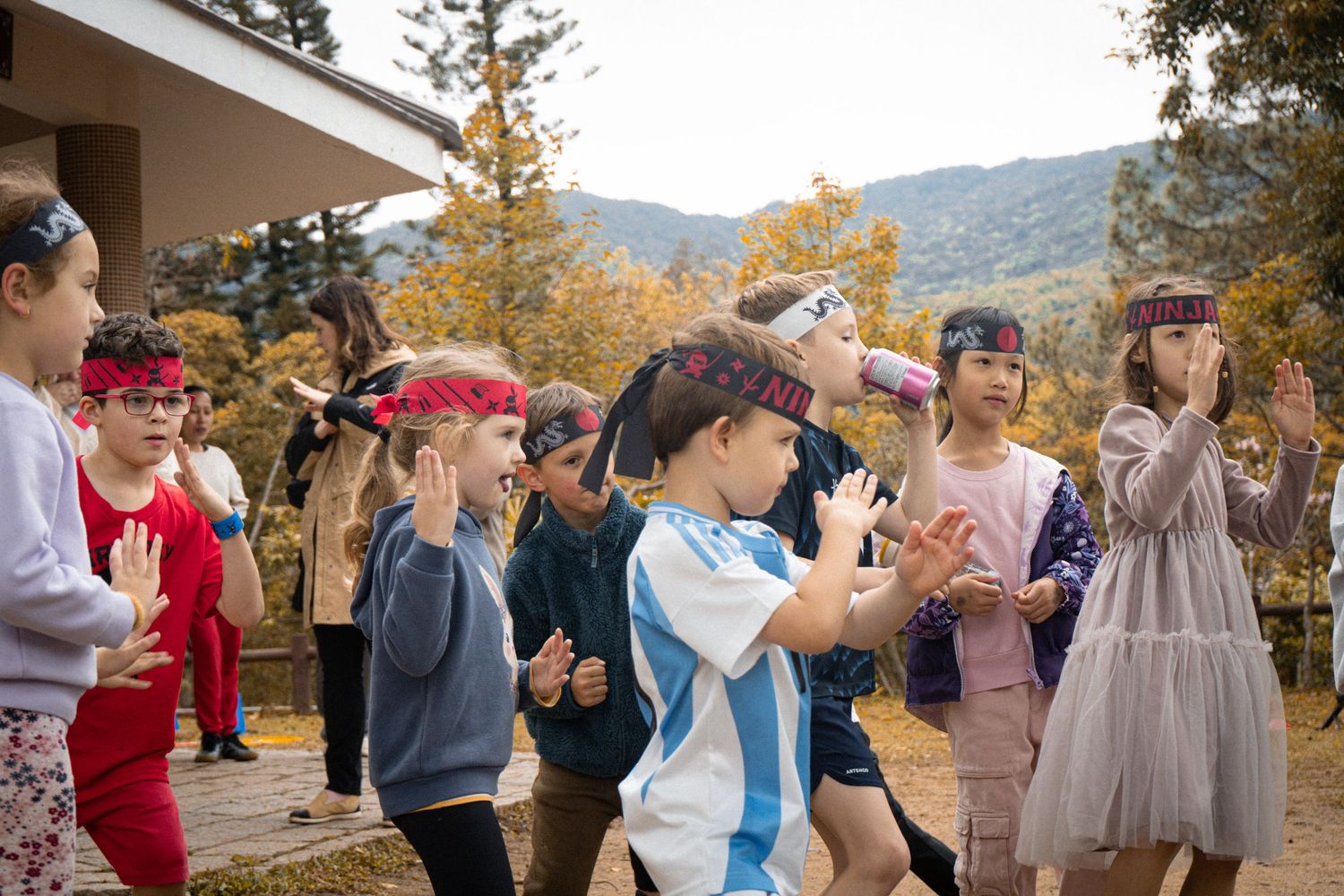 Children participating in interactive outdoor activity while wearing casual clothing and hats.