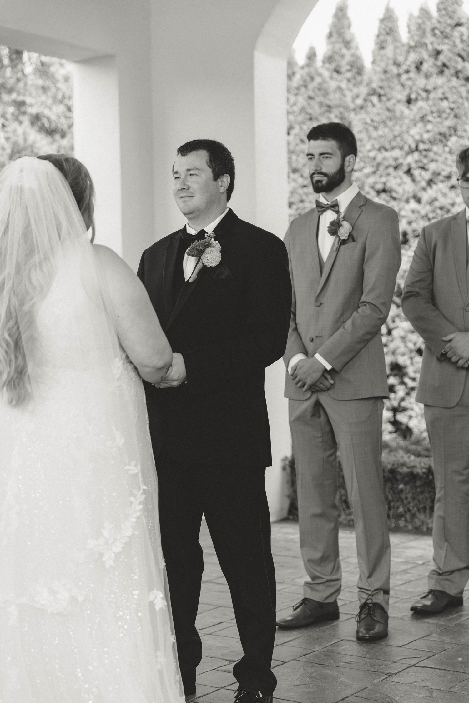 Black and white wedding ceremony photos showing intimate moments between couple and wedding party.