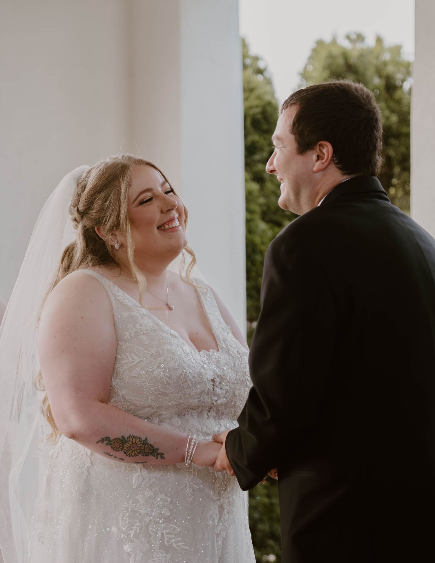 A couple shares a joyful first look moment during their wedding ceremony on a sunny day.