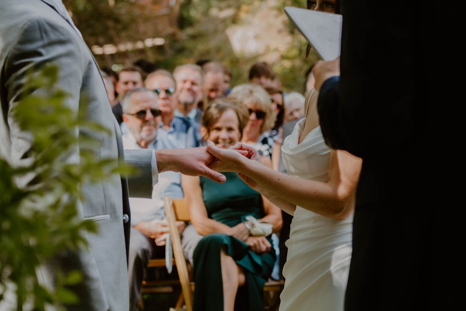 Wedding guests raise their champagne glasses in a celebratory toast during an outdoor reception.