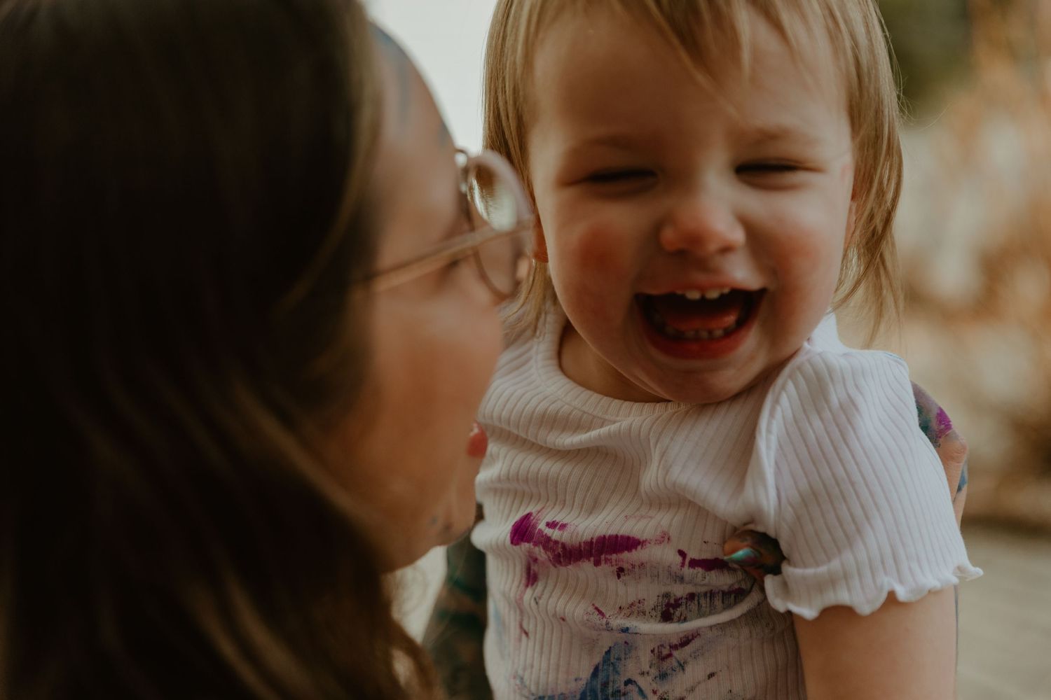 A joyful moment shared between parent and child with warm lighting and genuine laughter.