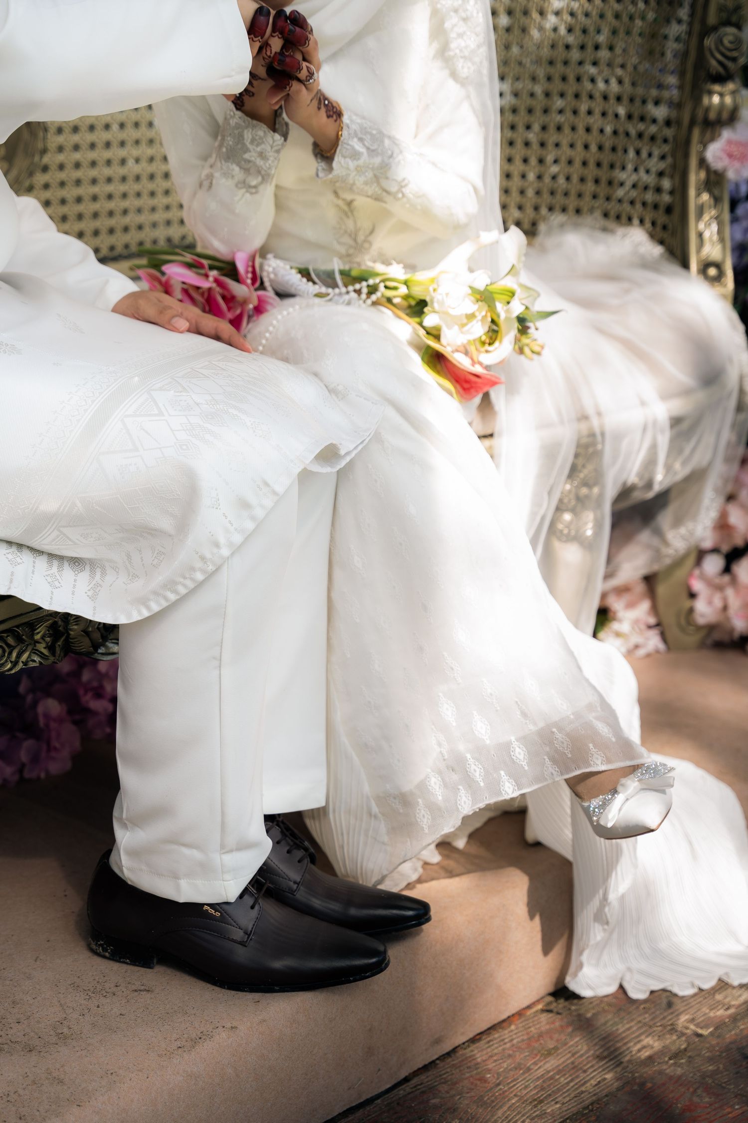 Close-up sequence showing white wedding dress flowing over black formal shoes on wooden floorboards.