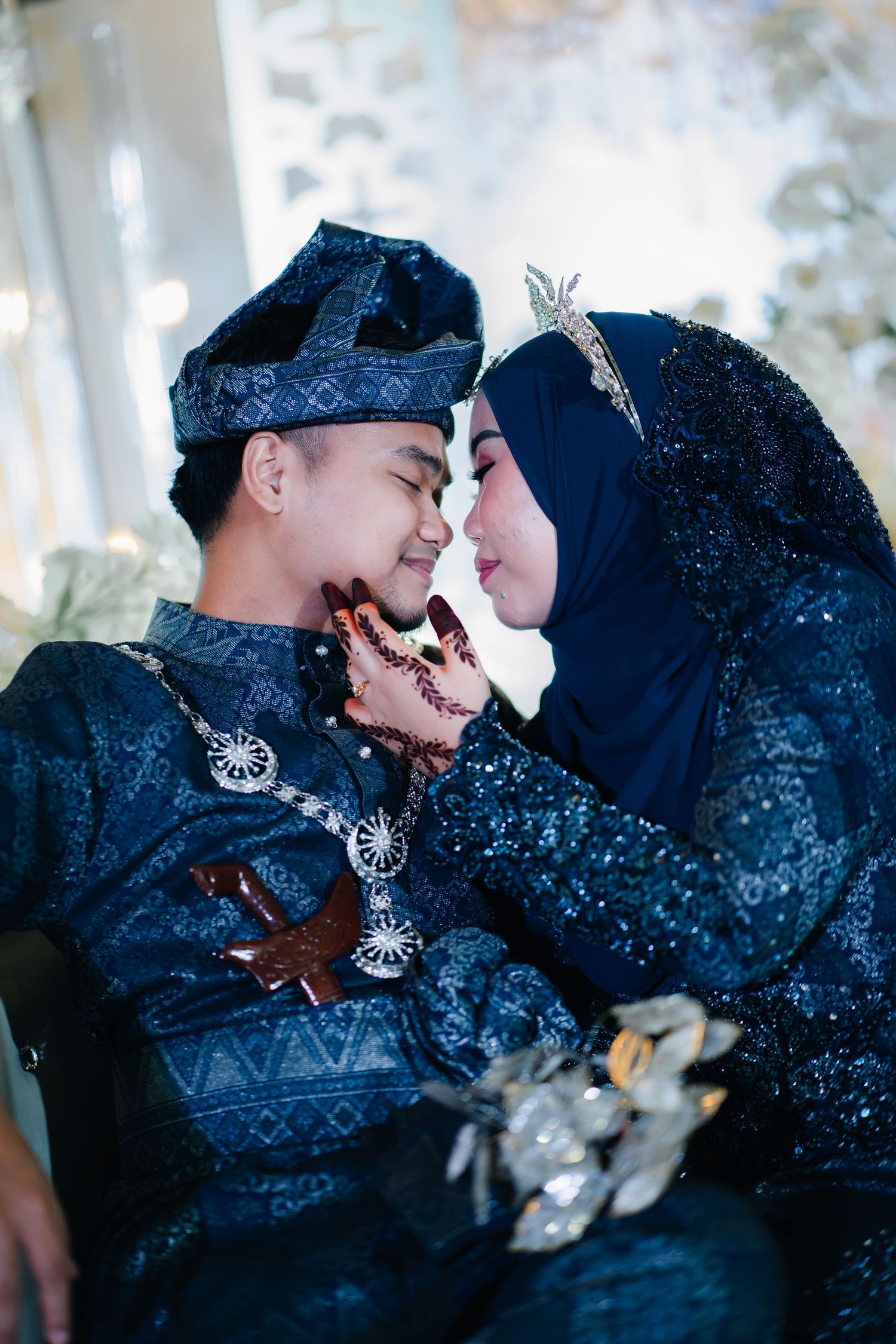 Romantic couple in traditional Muslim attire shares tender moments in a glittering winter scene during their photoshoot.