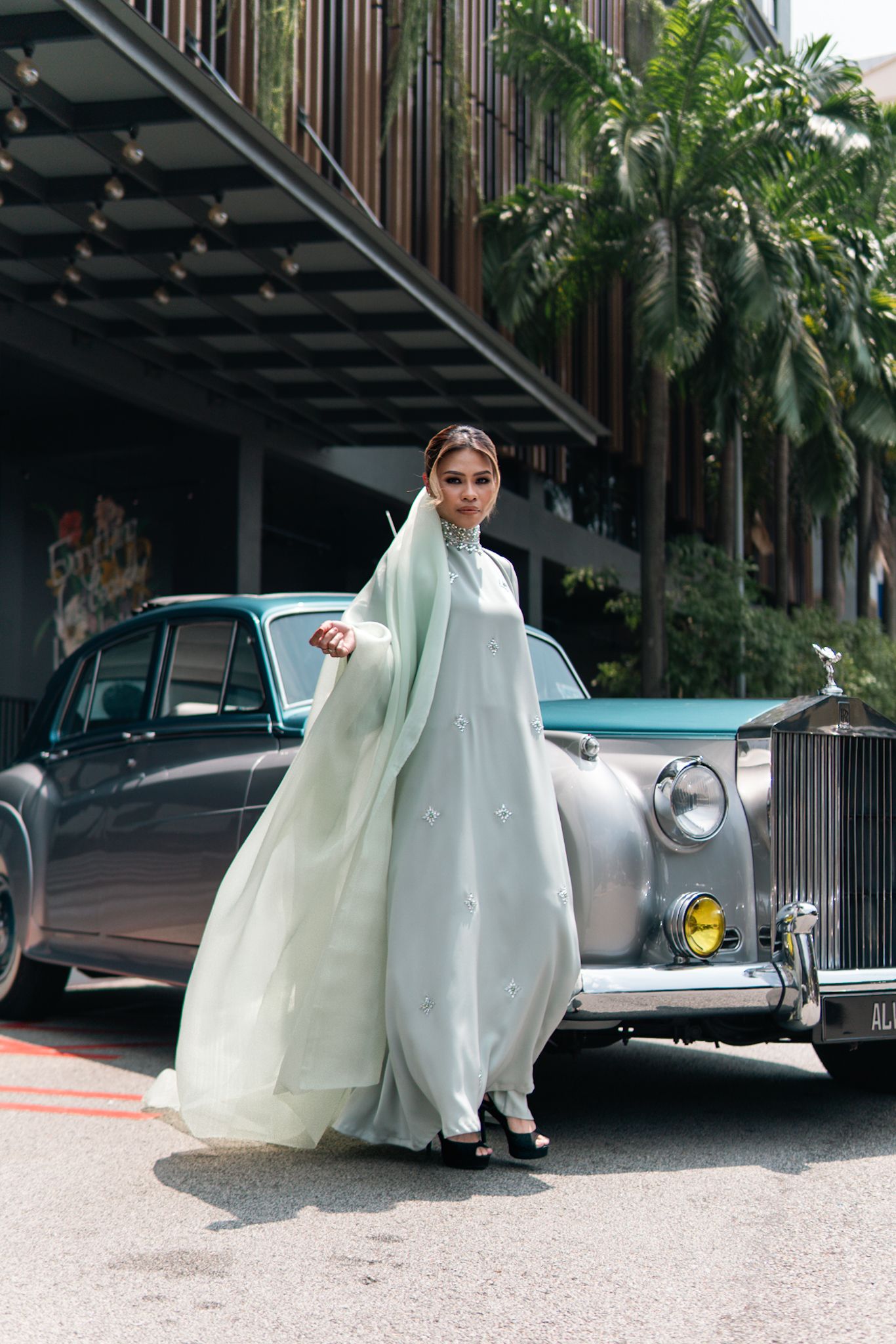 Mint green flowing dress captured against classic silver Rolls Royce and tropical architecture.