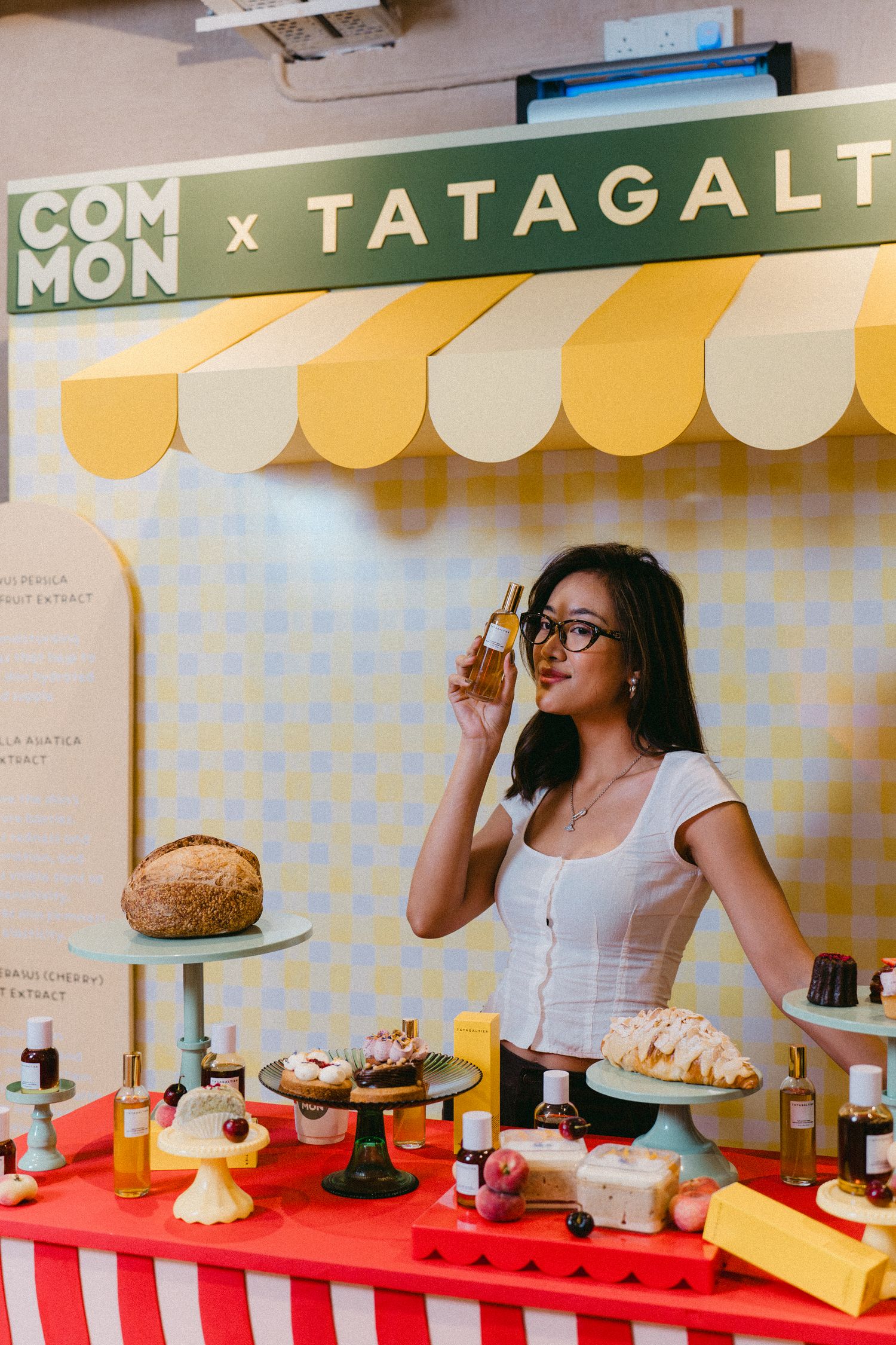 Retail display with pastries and baked goods under yellow and white striped awning.
