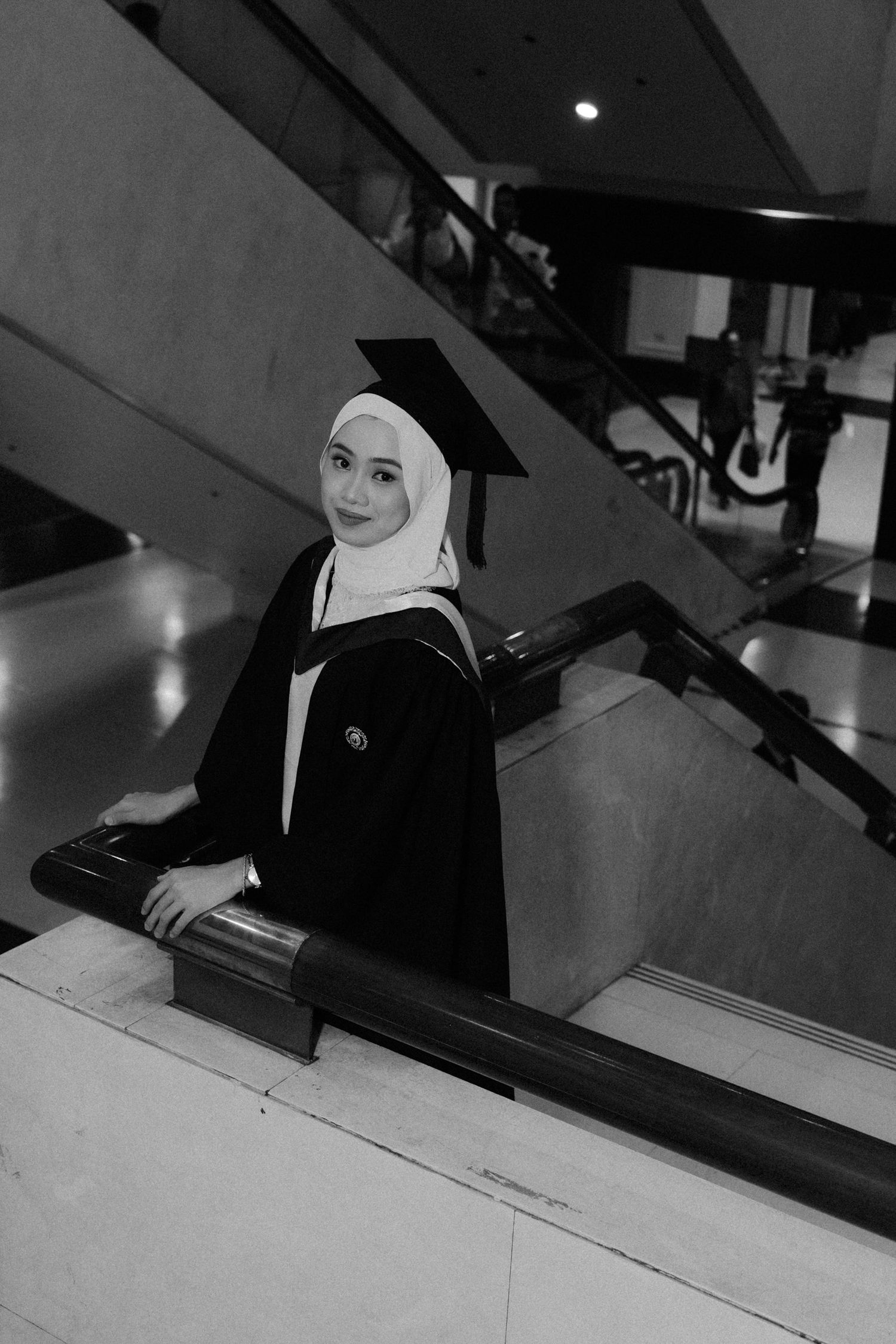 A black and white photo sequence showing a graduation cap and diploma being placed on a table.