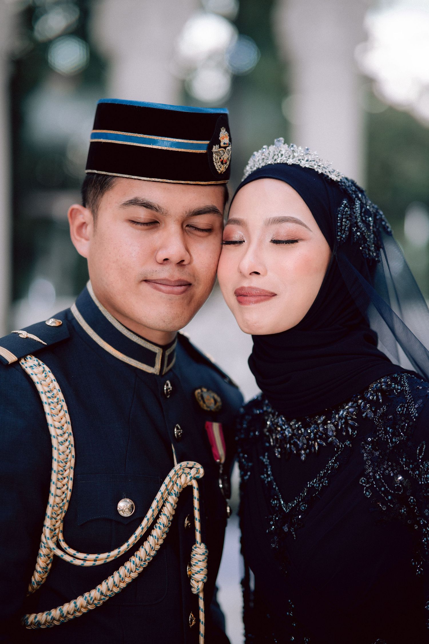 A couple shares an intimate moment wearing military formal dress and a traditional black beaded hijab wedding dress.
